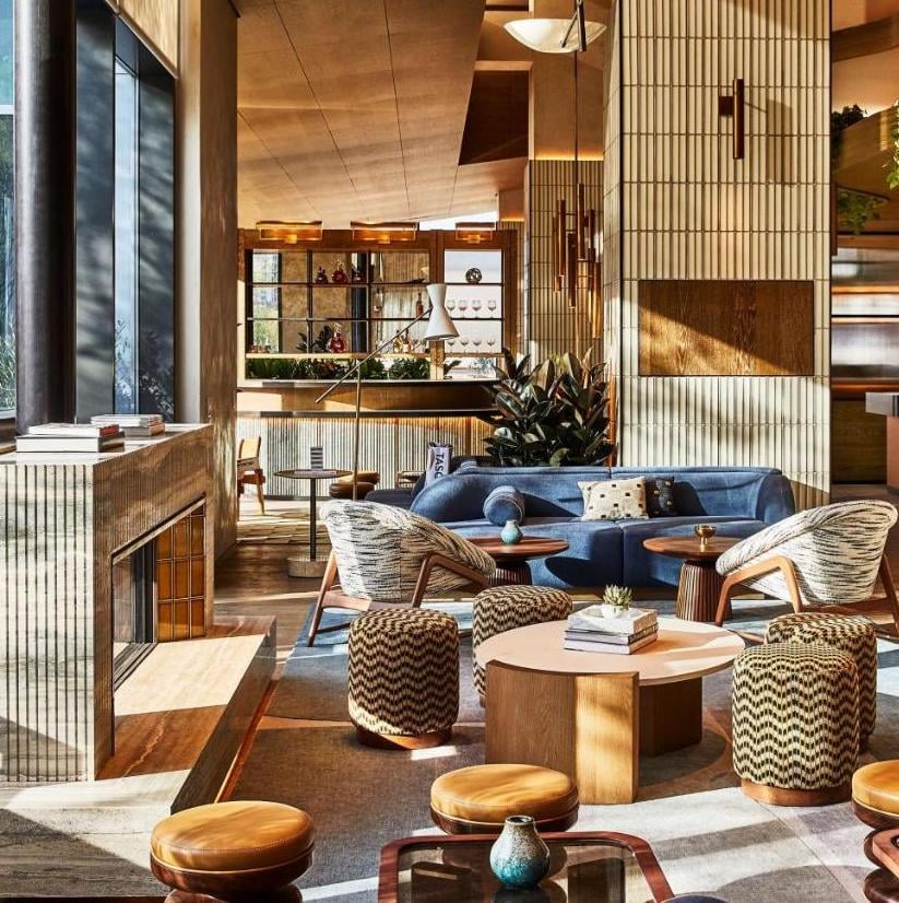Warm wood paneling and geometric patterns create an inviting sanctuary where natural light dances across plush seating and carefully curated design elements.