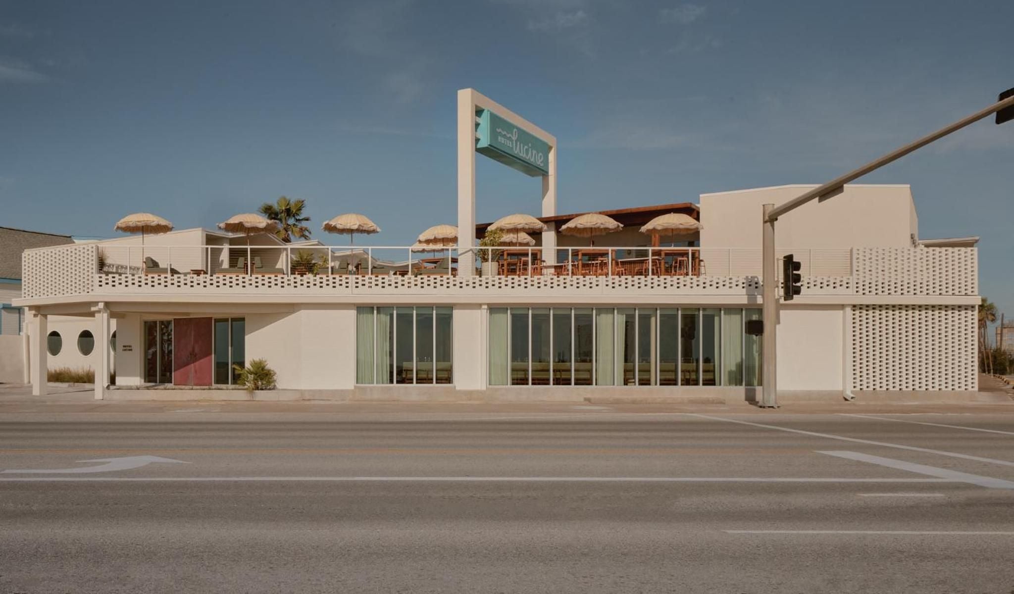 Mid-century modernist lines meet desert minimalism at this striking two-story facade, where rooftop umbrellas hint at elevated dining beneath endless Southwestern skies.