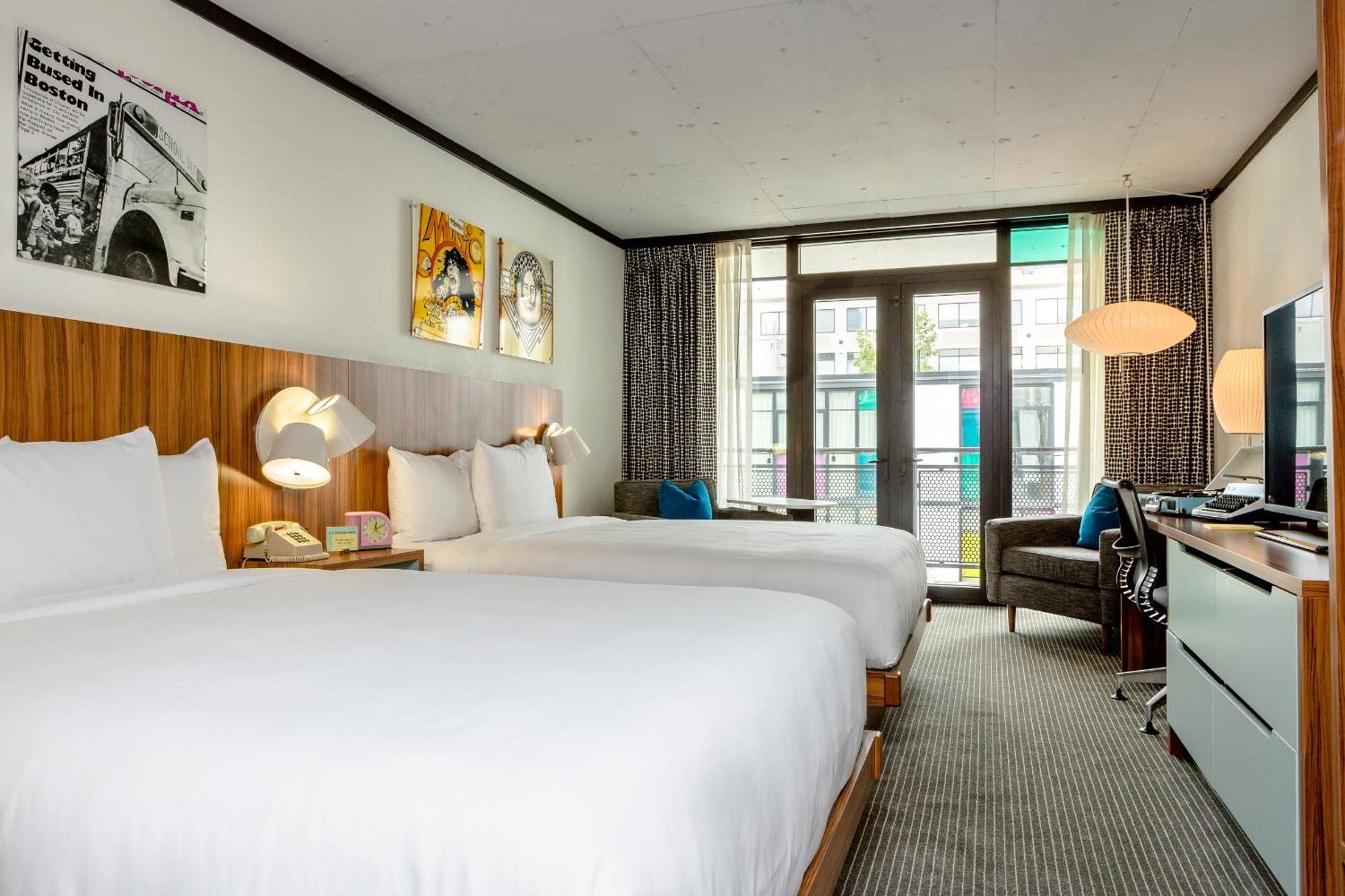 Twin beds with warm wood headboards and vintage concert posters create a rock-and-roll haven, while oversized windows flood the space with Boston daylight.