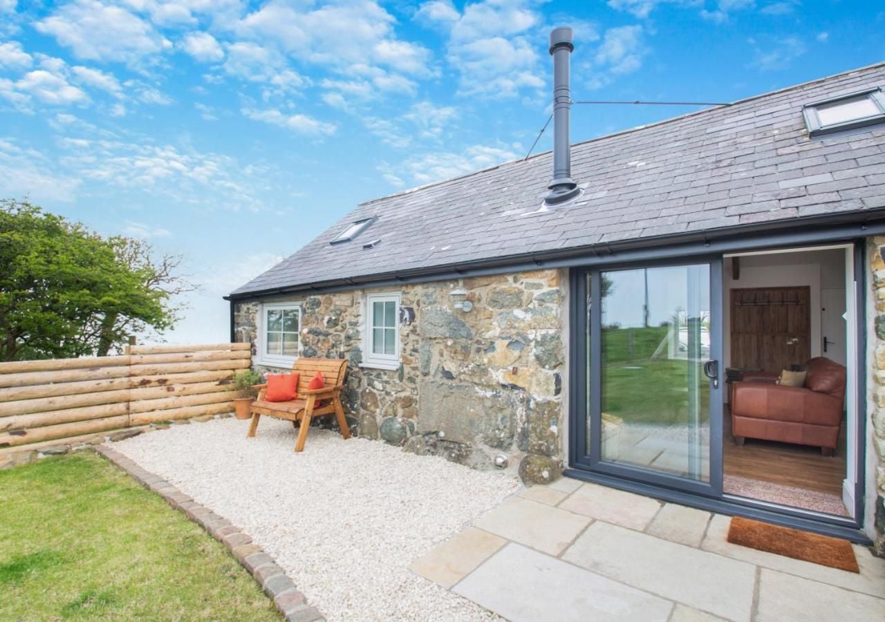 Stone walls weathered by coastal winds frame a private terrace where morning coffee tastes better against rolling green fields and endless sky.