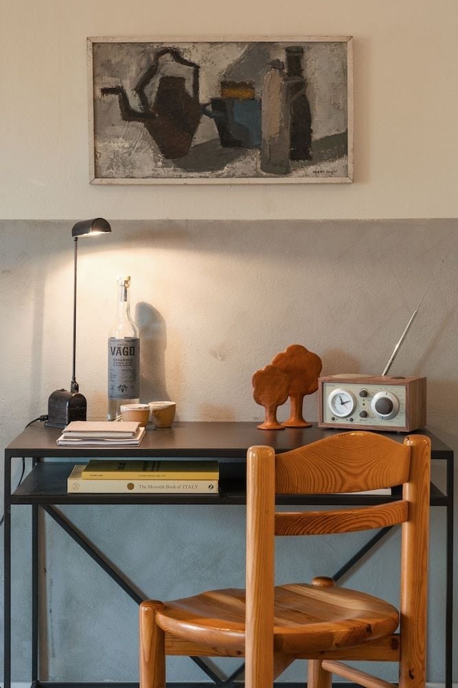 Mid-century furnishings and thoughtful lighting create an intimate workspace, where vintage radios and abstract art reflect the motel's nostalgic yet sophisticated design sensibility.