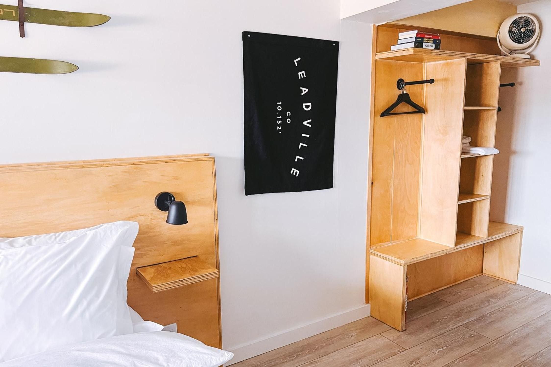 Warm plywood built-ins maximize every inch in this thoughtfully designed guest room, where Scandinavian functionality meets surfboard-adorned walls and crisp white linens.