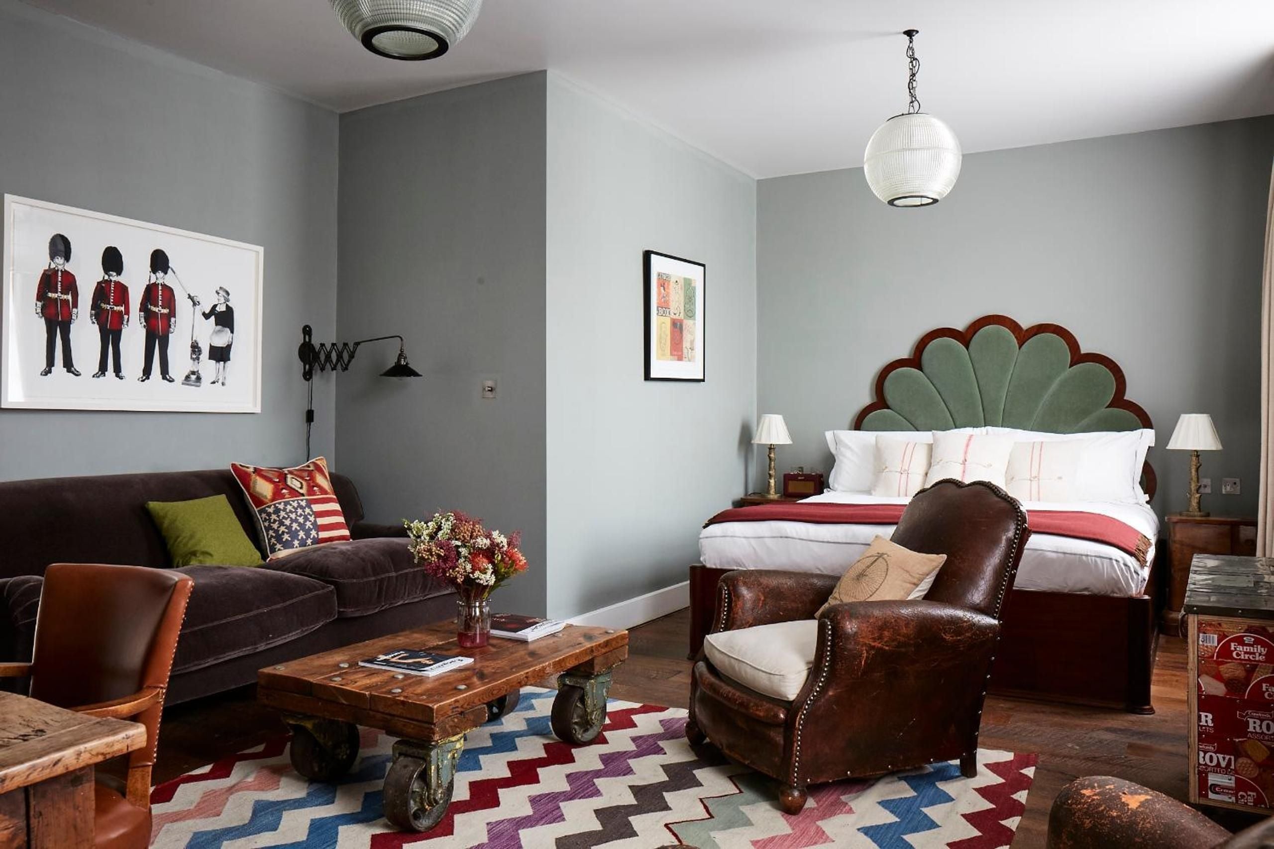 Eclectic British charm meets boutique comfort in this thoughtfully curated suite, where vintage leather mingles with contemporary art and bold geometric patterns create intimate sophistication.