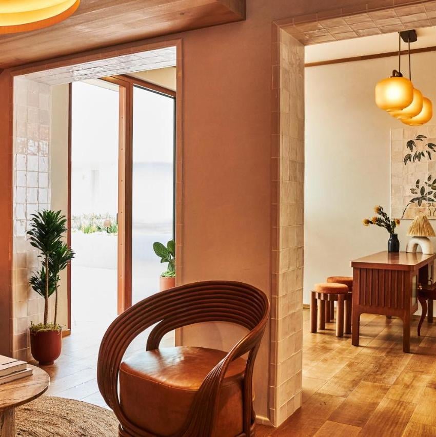 Warm wood tones and sculptural pendant lighting create intimate corners throughout this mid-century modern retreat, where natural light bathes handcrafted furniture in golden hues.