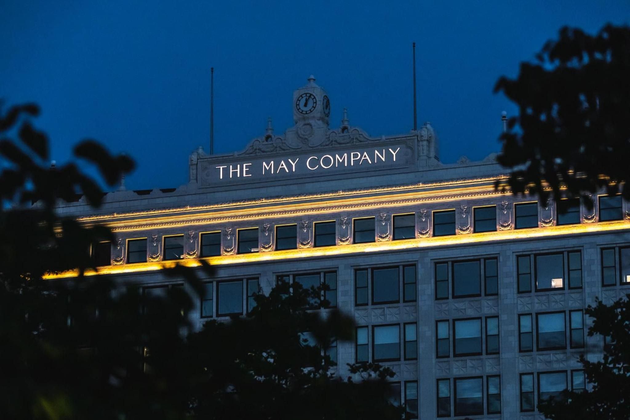 Cleveland's historic May Company building glows against twilight sky, its ornate clock tower and golden facade lighting creating an enchanting urban backdrop for evening strolls.