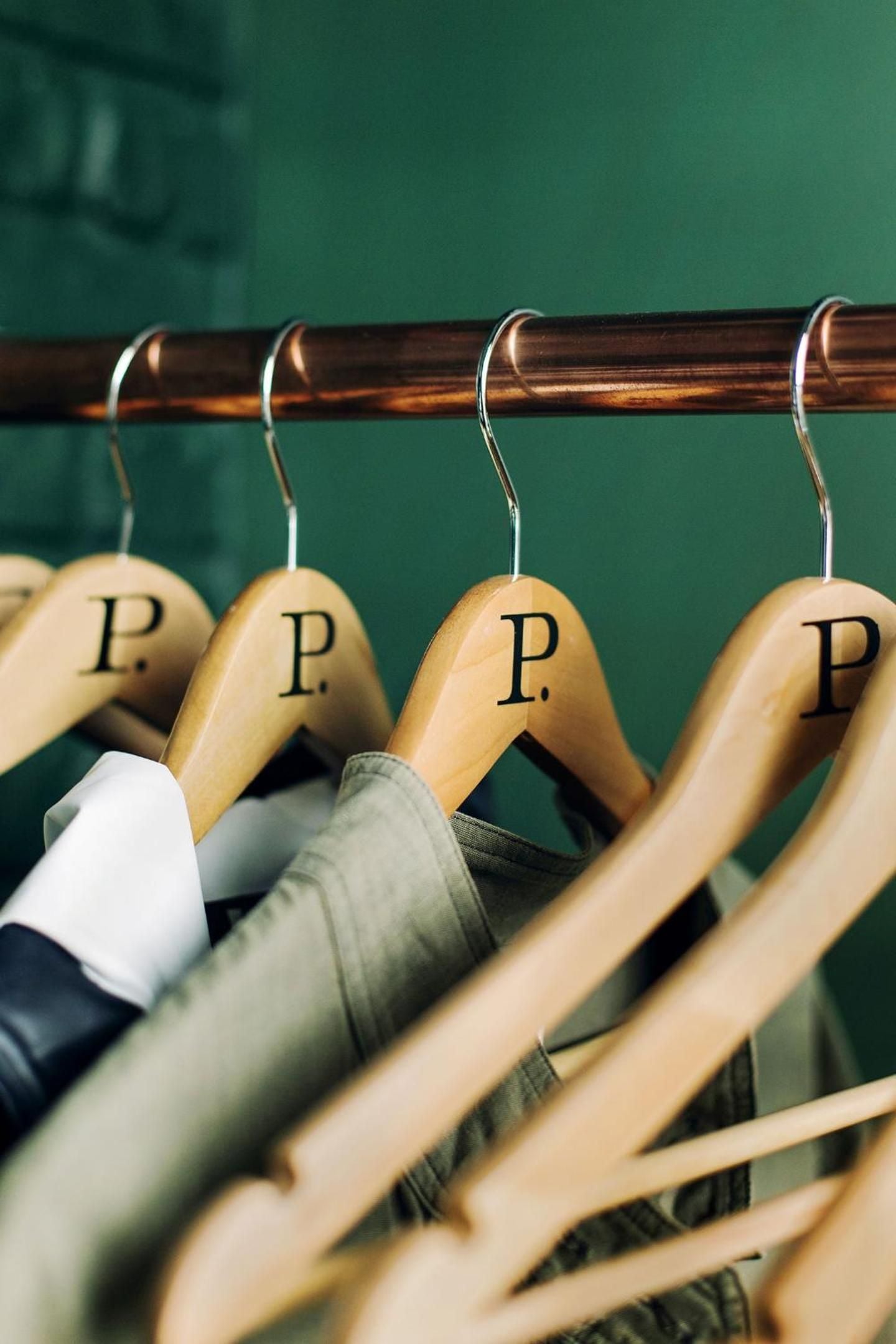 Branded wooden hangers line the closet rail, where pressed shirts and tailored jackets await the next day's adventures in downtown Seattle.