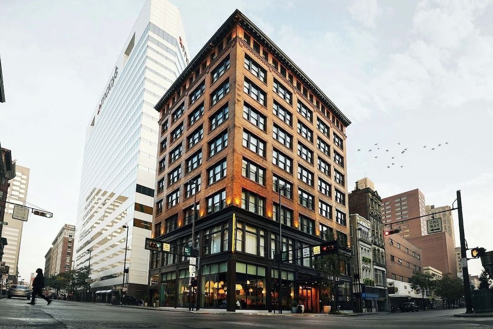 Red brick facades and towering glass neighbors frame this corner gem, where historic architecture meets Cincinnati's evolving downtown pulse at golden hour.