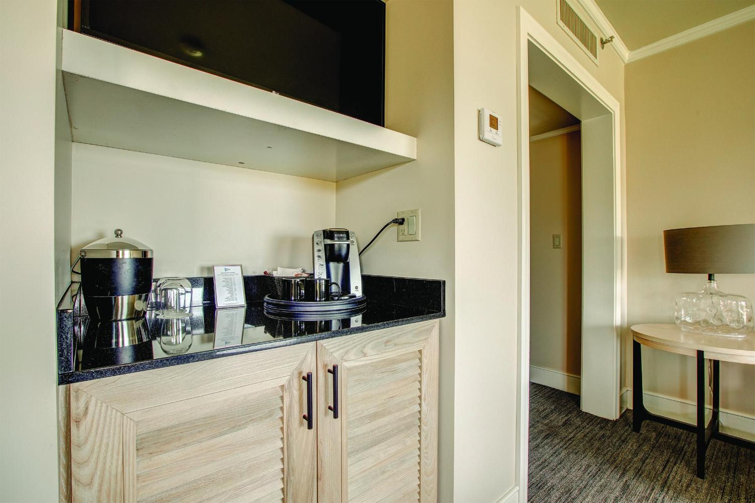 Light wood cabinetry and granite counters frame a well-appointed kitchenette, where thoughtful amenities create an inviting space for lakeside retreat moments.