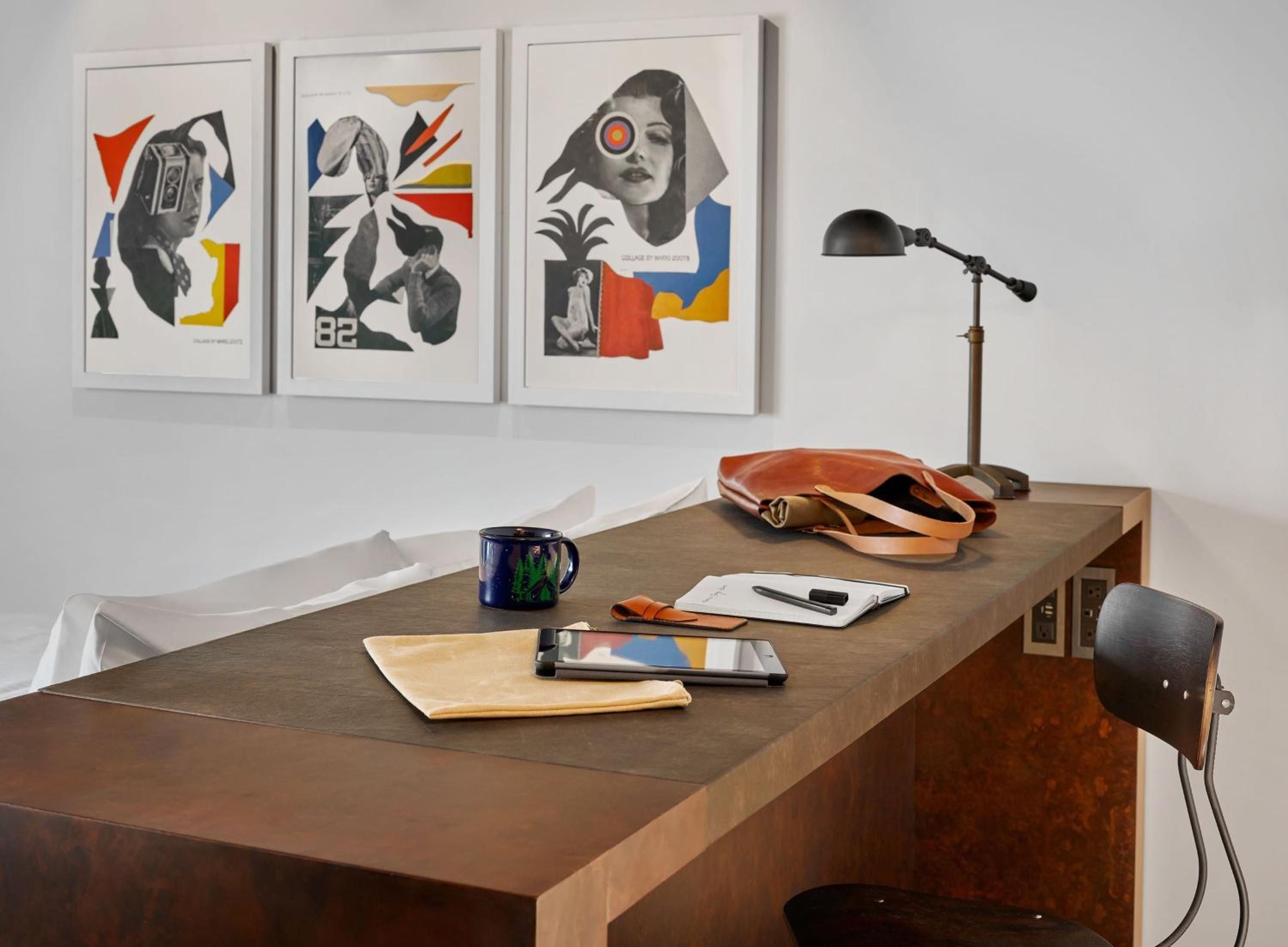 Mid-century modern meets contemporary cool in thoughtfully appointed guest rooms, where curated art collections and warm wood desks create an inspiring creative workspace.