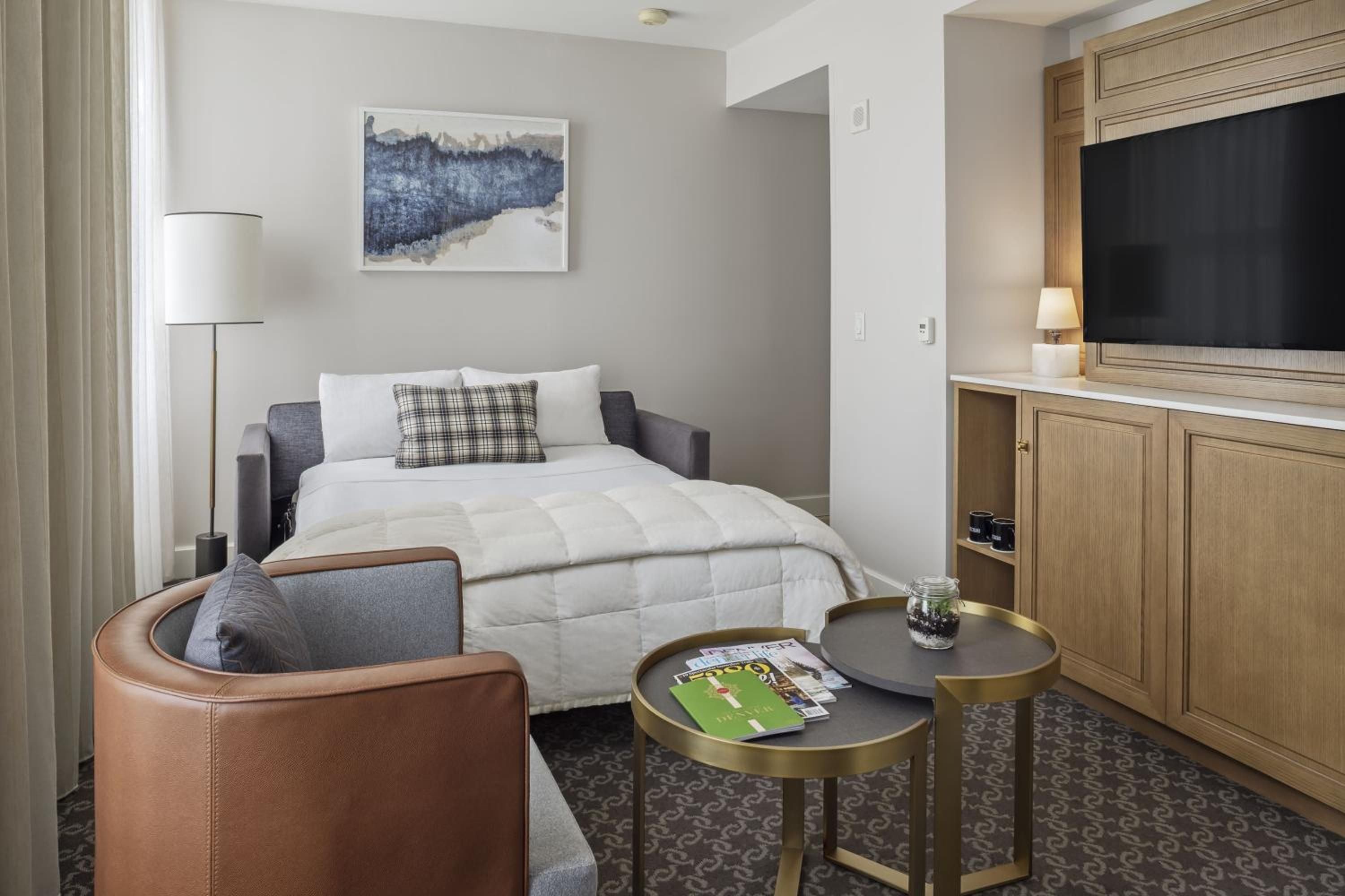 Warm wood cabinetry and plaid accents create an intimate retreat where leather seating invites lingering over coffee and magazines.