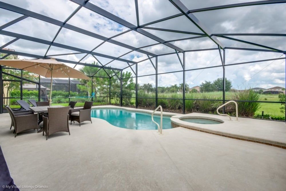 Screened lanai creates perfect sanctuary where turquoise pool waters reflect dramatic Florida skies while wicker seating invites leisurely afternoons overlooking manicured golf course greens.