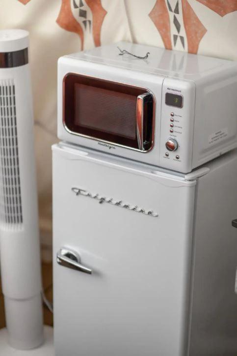 Vintage Frigidaire charm meets modern convenience in this thoughtfully curated glamping space, where retro appliances and warm lighting create an unexpectedly homey retreat.