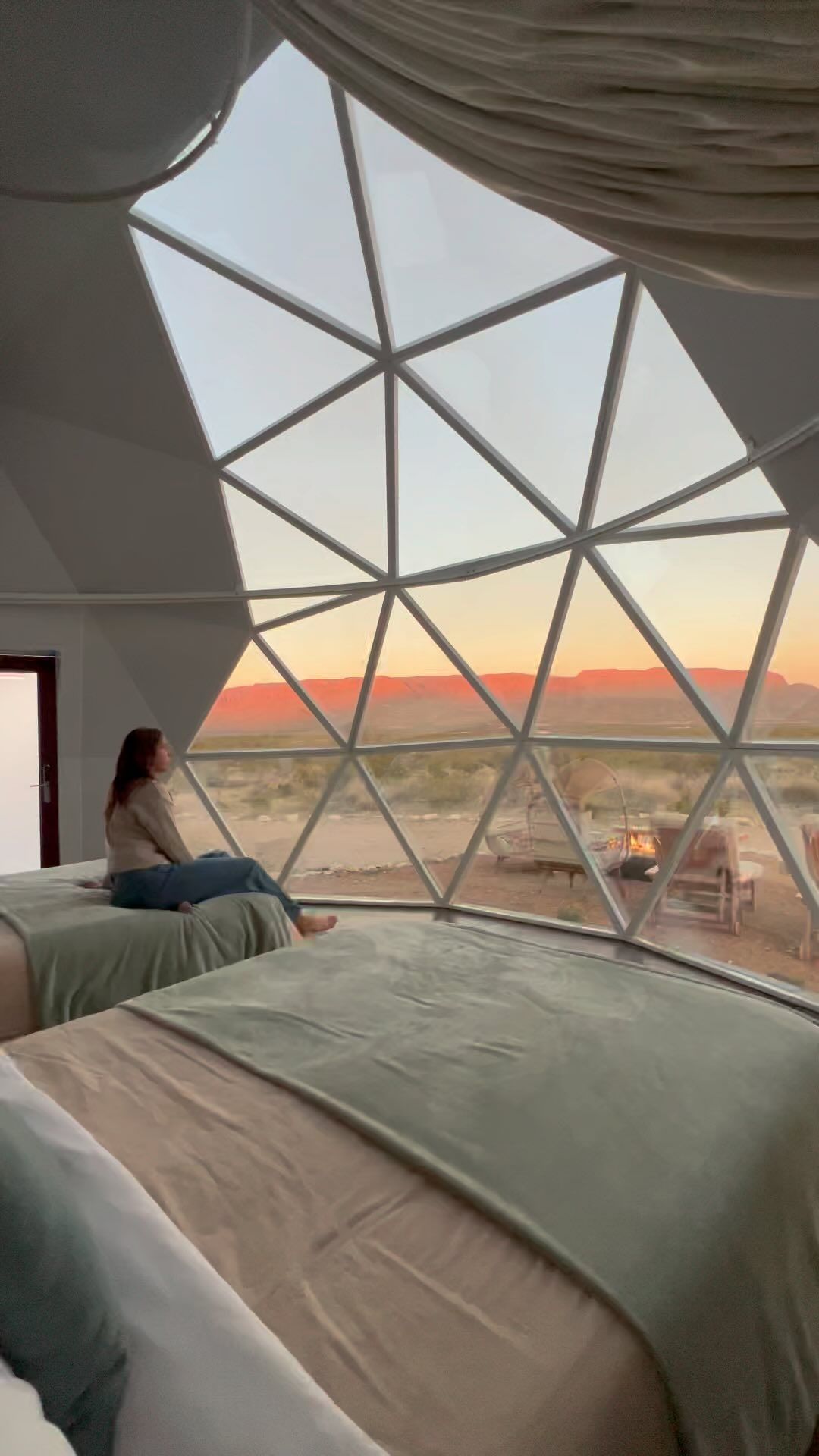 Morning light filters through geometric glass panels as desert vistas unfold beyond the geodesic dome's triangular framework, creating an otherworldly sanctuary above Red River's rugged landscape.