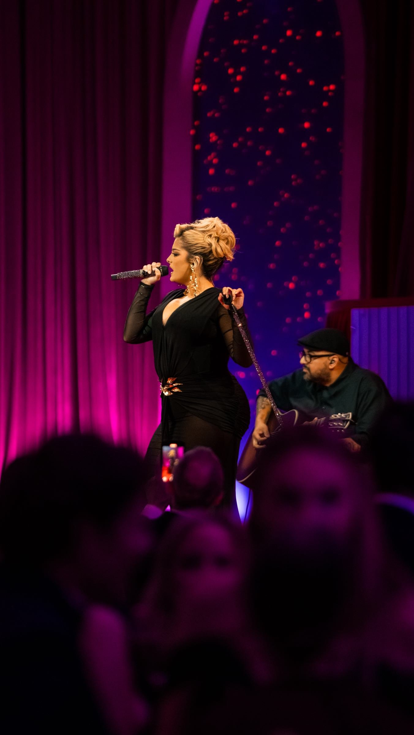 Intimate live music performances create magical evenings, with purple stage lighting casting a warm glow over talented musicians entertaining guests in this cozy venue setting.