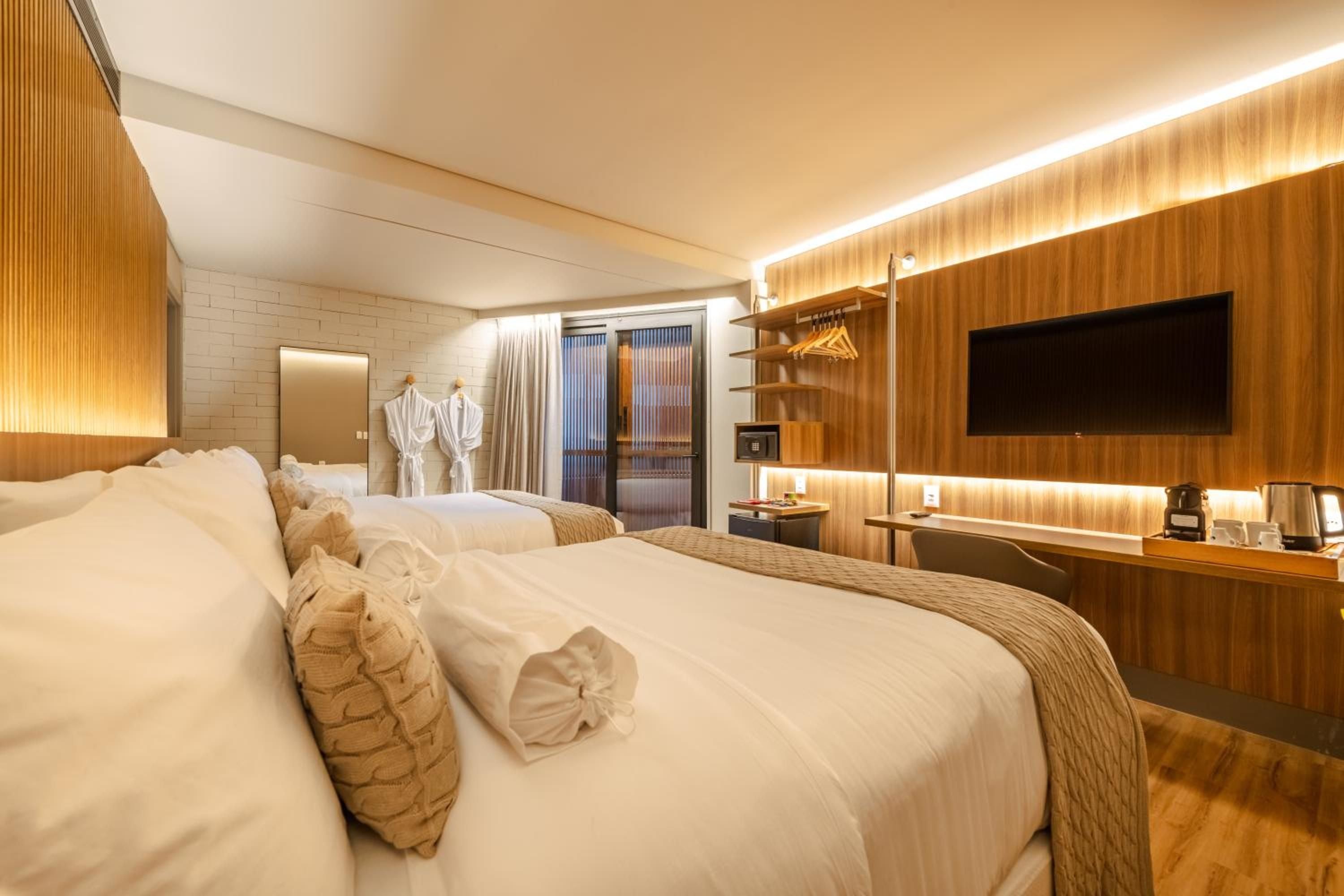Warm wood paneling and hidden LED lighting create an intimate cocoon, while crisp white linens and thoughtful amenities transform this suite into a sophisticated urban retreat.