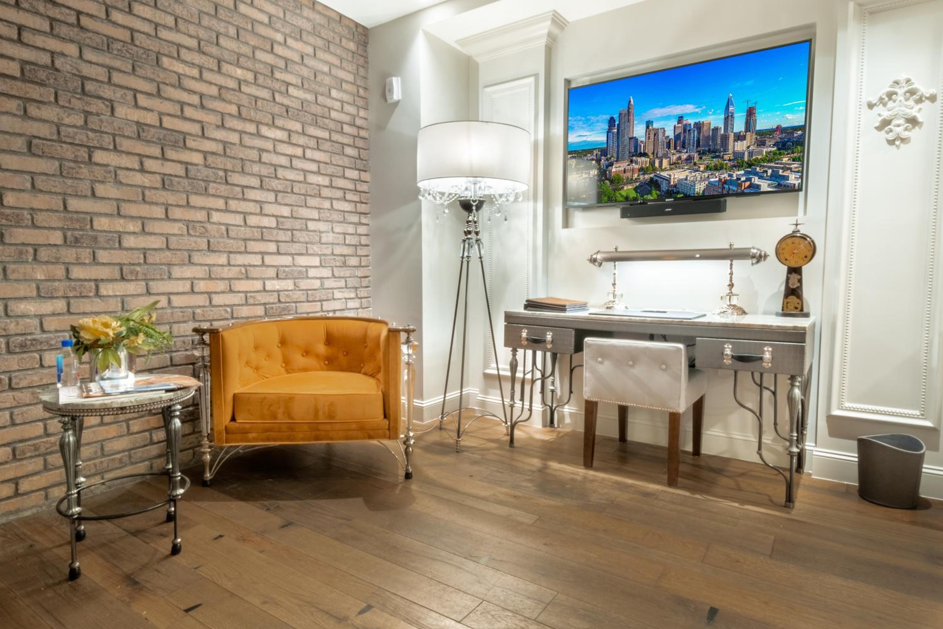 Exposed brick meets modern luxury in this thoughtfully appointed workspace, where buttery leather seating and industrial-chic accents create an inviting urban retreat.