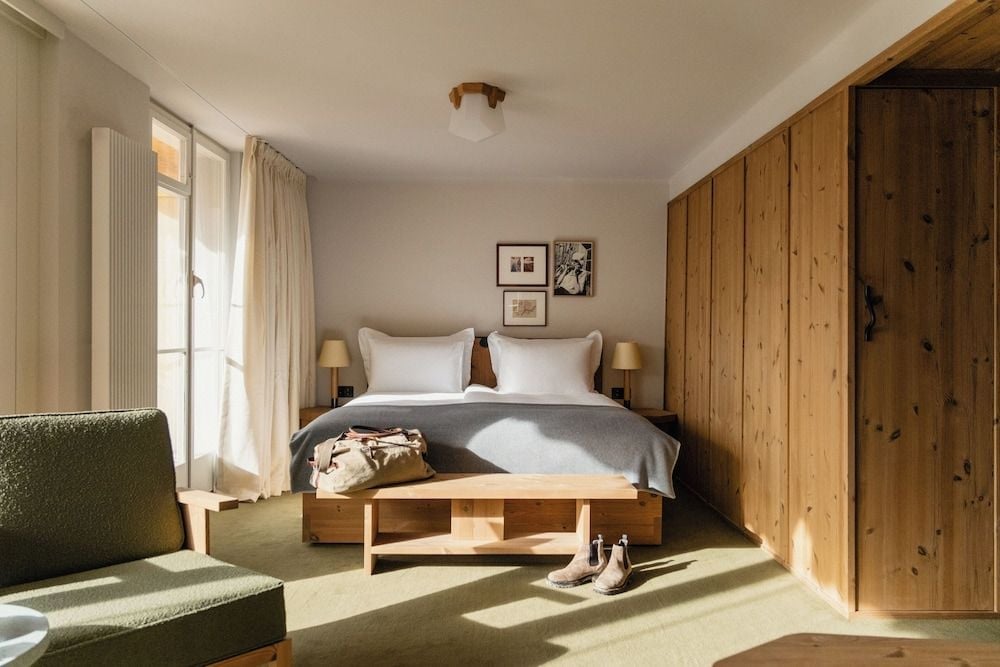 Warm pine wood and soft morning light create an intimate Alpine sanctuary, where handcrafted furnishings and neutral linens invite peaceful mountain slumber.