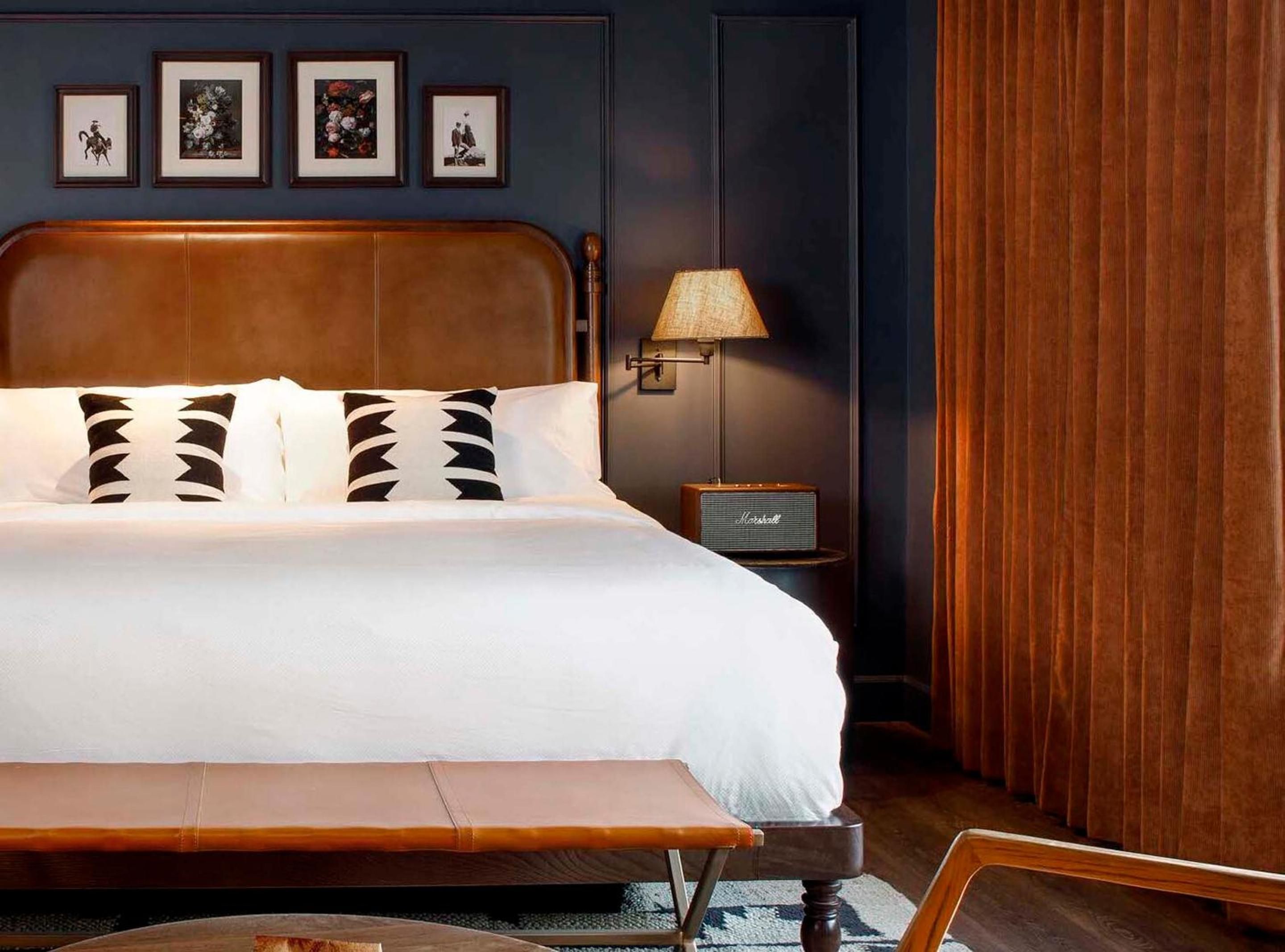 Rich cognac leather and deep navy walls create an intimate cocoon, where geometric pillows and vintage Marshall speakers hint at Denver's creative pulse.