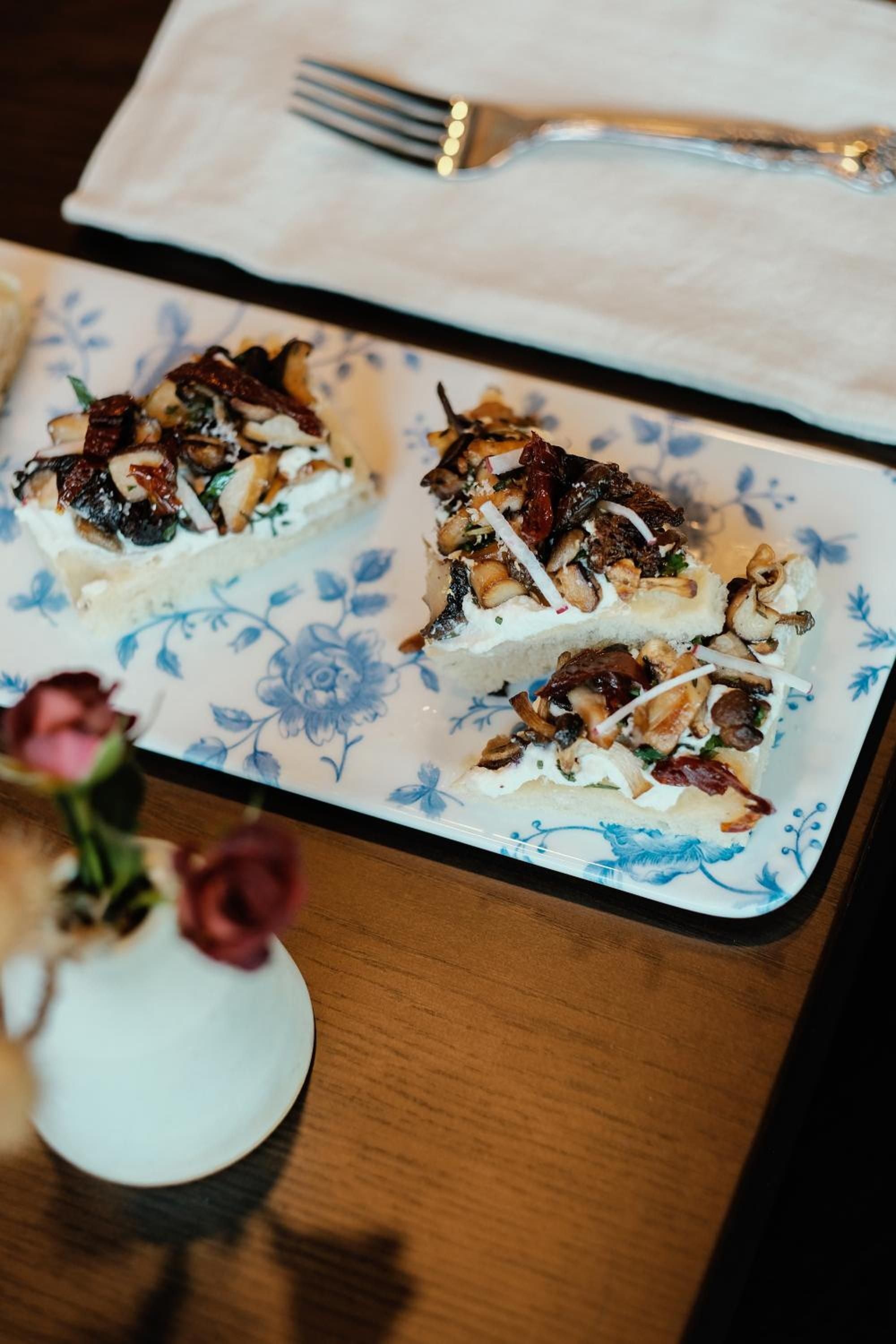 Artfully plated appetizers showcase wild mushrooms and creamy cheese on delicate blue-and-white porcelain, setting an elegant tone for mountain dining experiences.