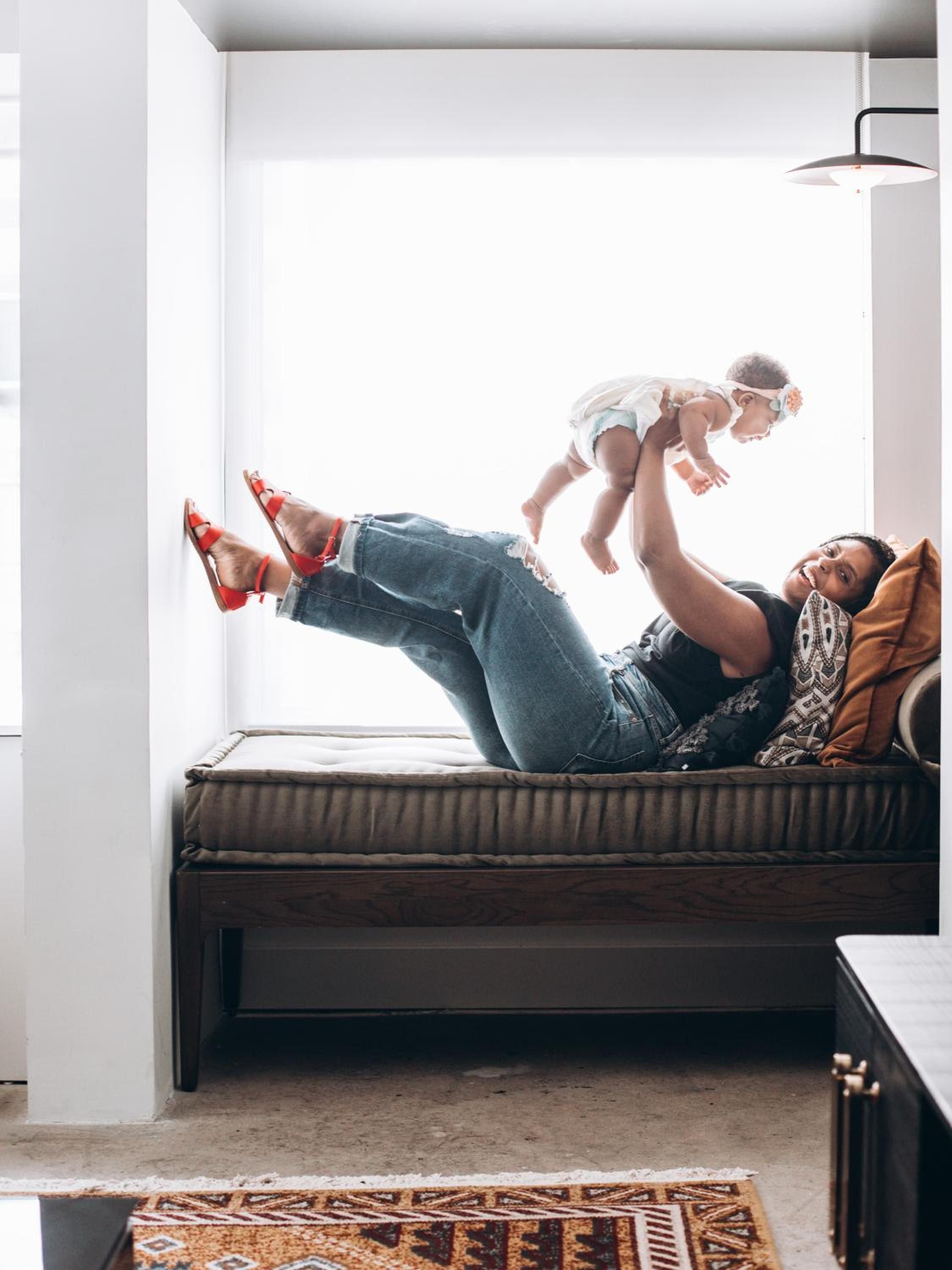 Moments of pure joy unfold in thoughtfully designed suites where modern comfort meets family connection, red heels kicked up against pristine white walls.