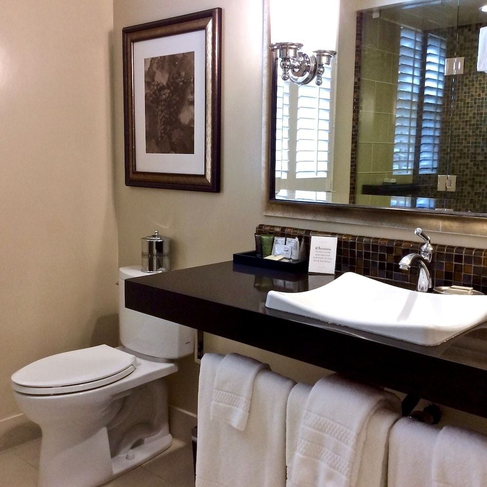 Mosaic tile backsplash and sleek vessel sink create spa-like sophistication in guest bathrooms, where crisp linens and thoughtful amenities elevate everyday rituals.
