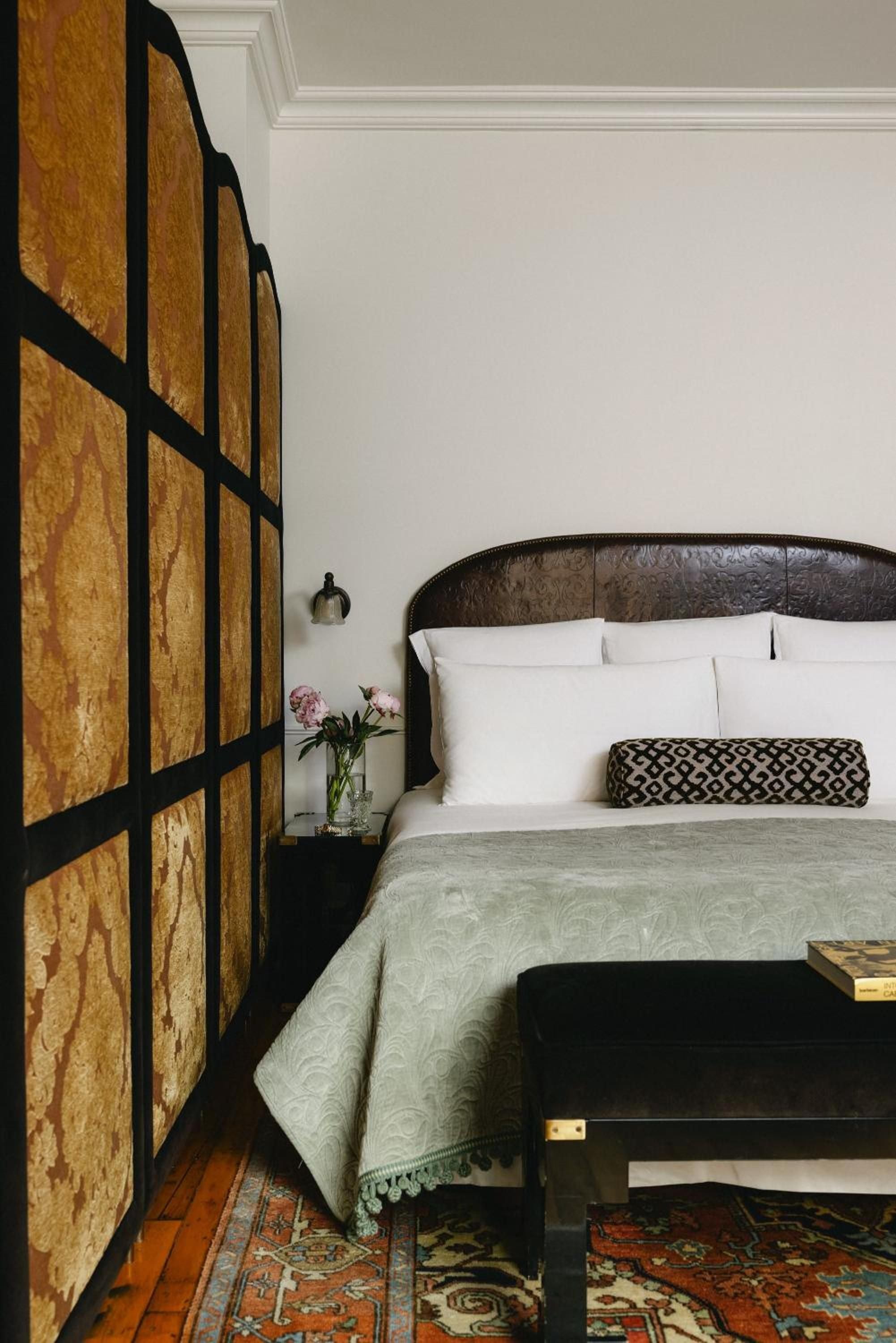 Burl wood panels frame intimate quarters where leather headboards meet crisp linens, creating a sophisticated cocoon above Persian rugs and polished floors.