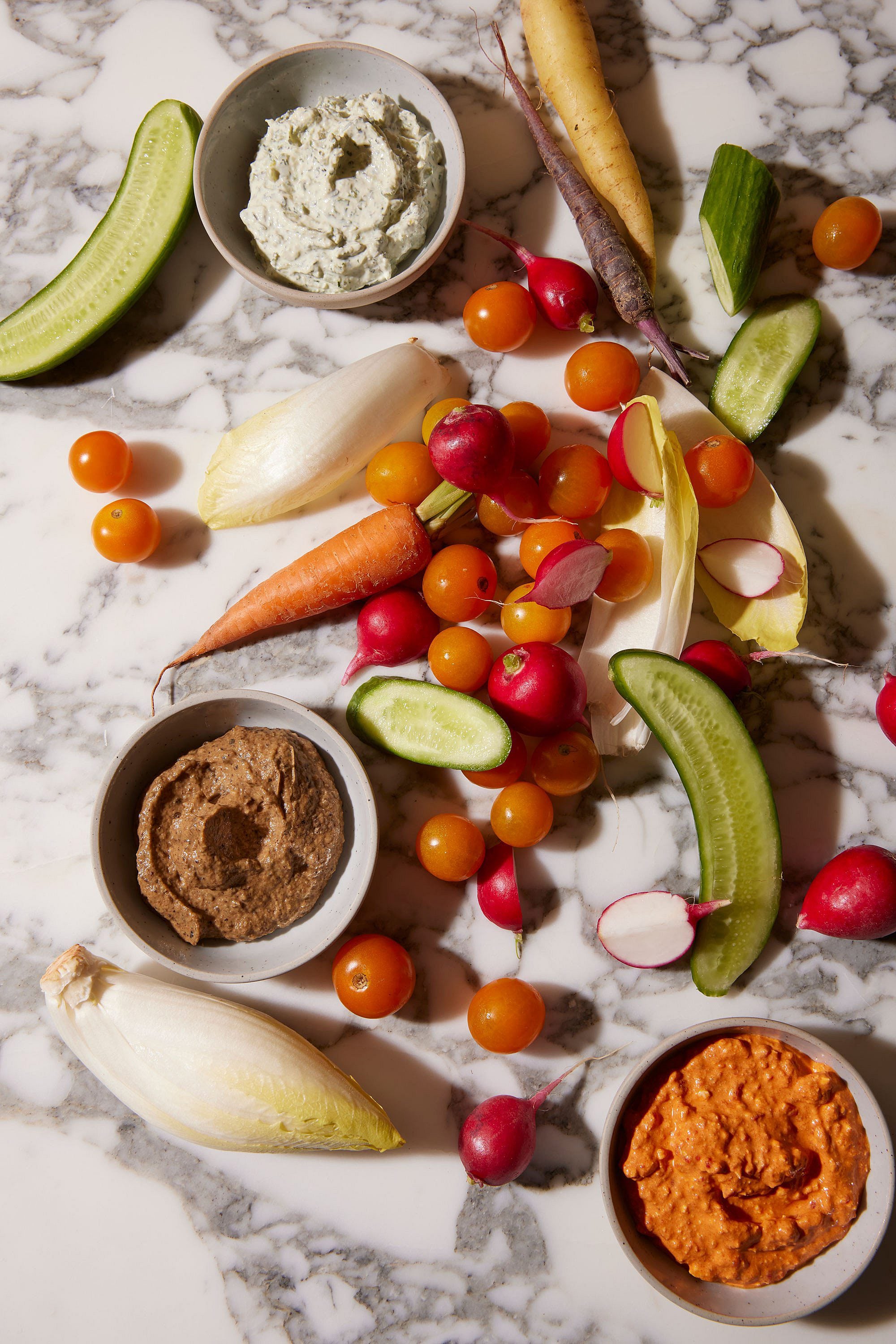Farm-fresh vegetables and house-made dips create an artful crudité spread on marble countertops, showcasing Inness's commitment to seasonal, locally-sourced cuisine.