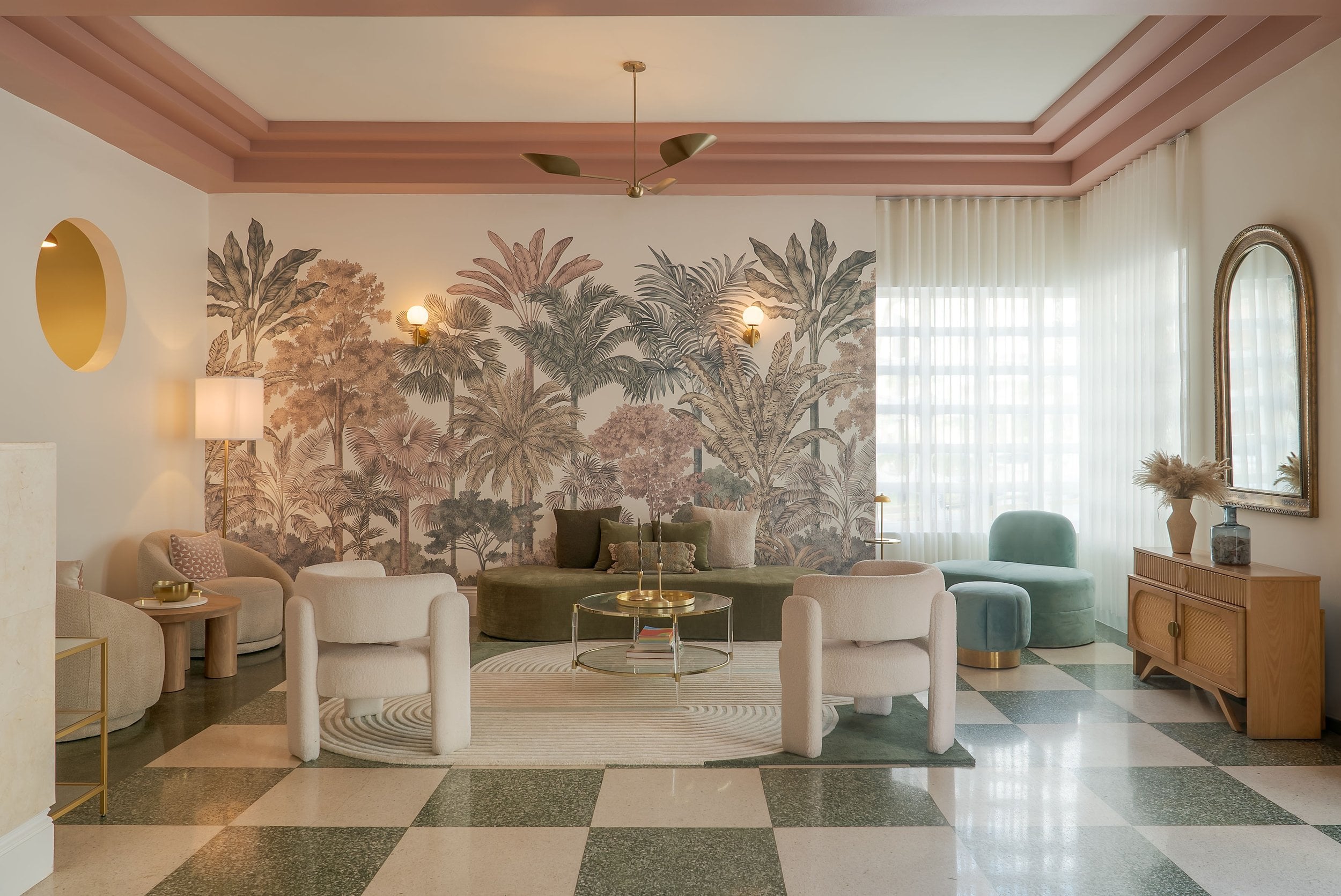 Terrazzo checkerboard floors and tropical botanical wallpaper create a sophisticated jungle-meets-Miami vibe in this sun-drenched lounge, where plush velvet seating invites lingering.