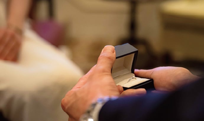 Moments before a proposal unfold in hushed anticipation, as gentle hands reveal a sparkling promise within silk-lined confines of an elegant jewelry box.