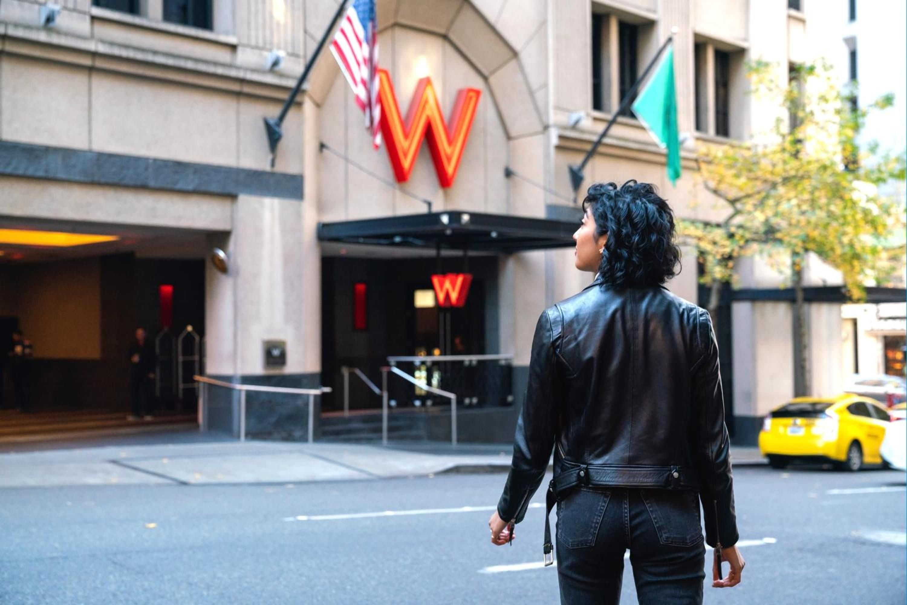 Bold red signage commands attention on this sophisticated downtown Seattle corner, where urban energy meets W's signature style against classic Pacific Northwest architecture.