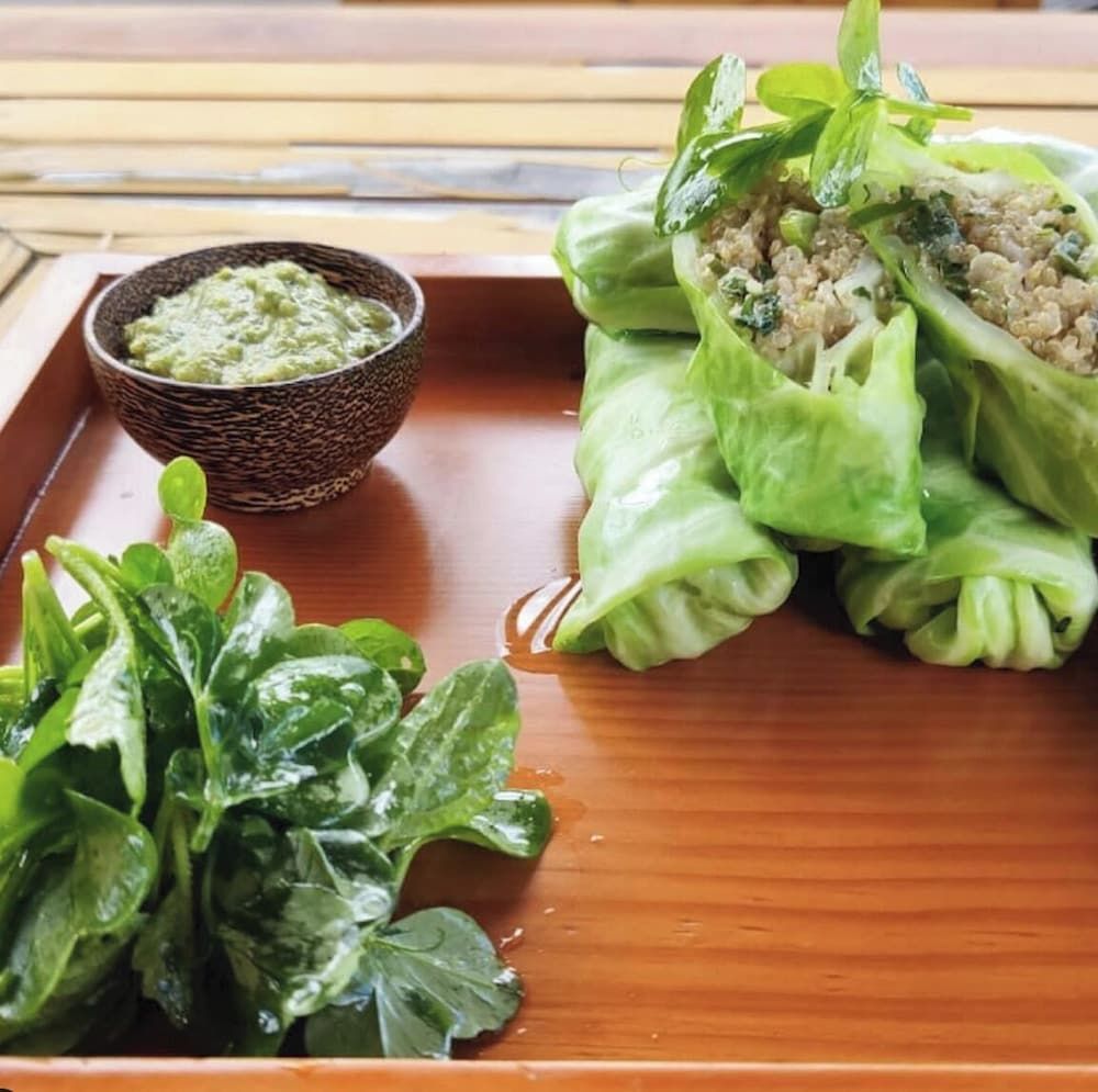 Fresh lettuce wraps filled with herbed quinoa arrive alongside vibrant green chutney, showcasing the hotel's commitment to locally-sourced Bhutanese ingredients and healthy mountain cuisine.