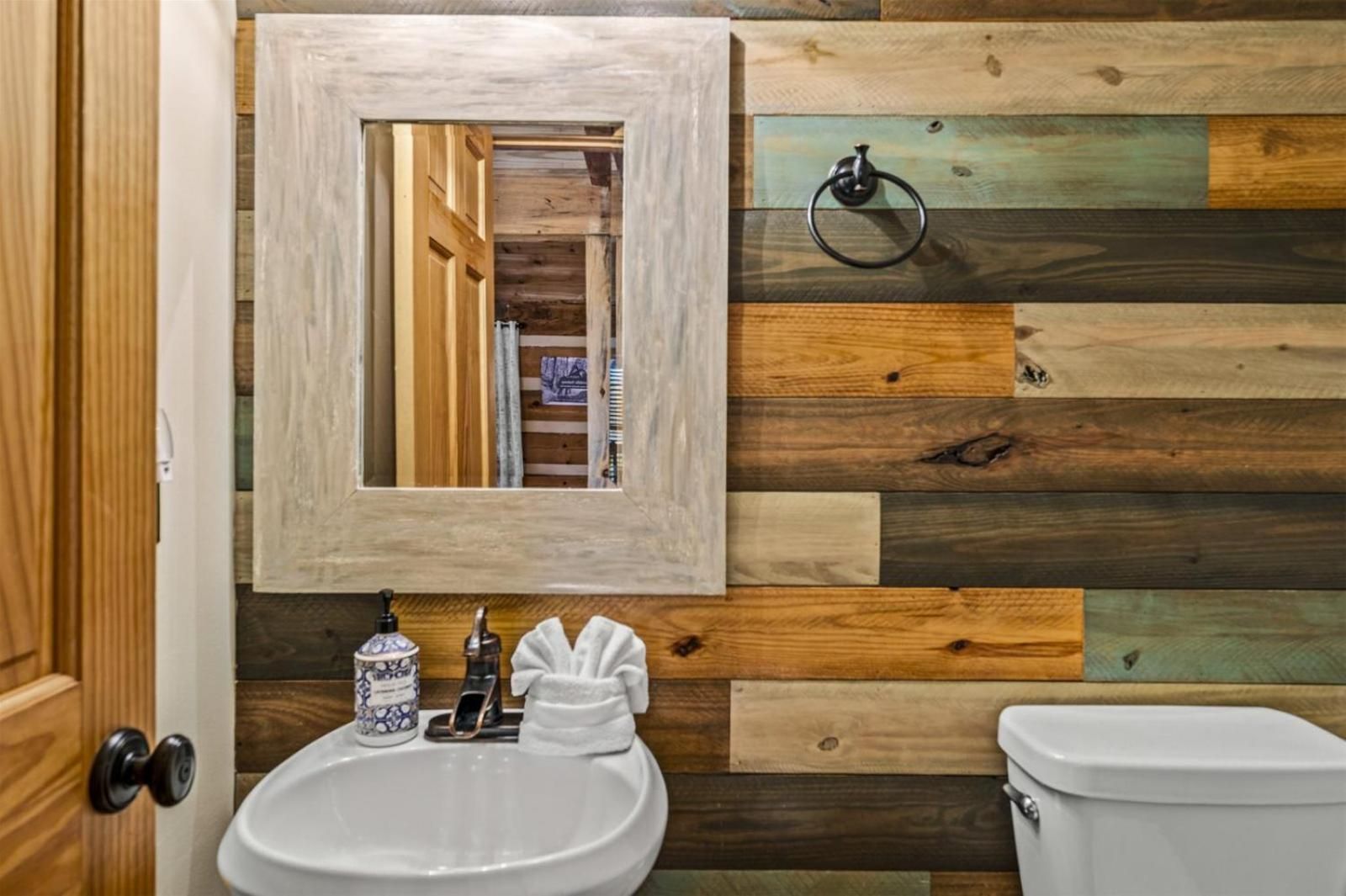 Reclaimed wood planks in weathered greens and golds create a rustic sanctuary, where artisanal touches and whitewashed mirrors reflect Blackberry Farm's mountain craftsmanship.