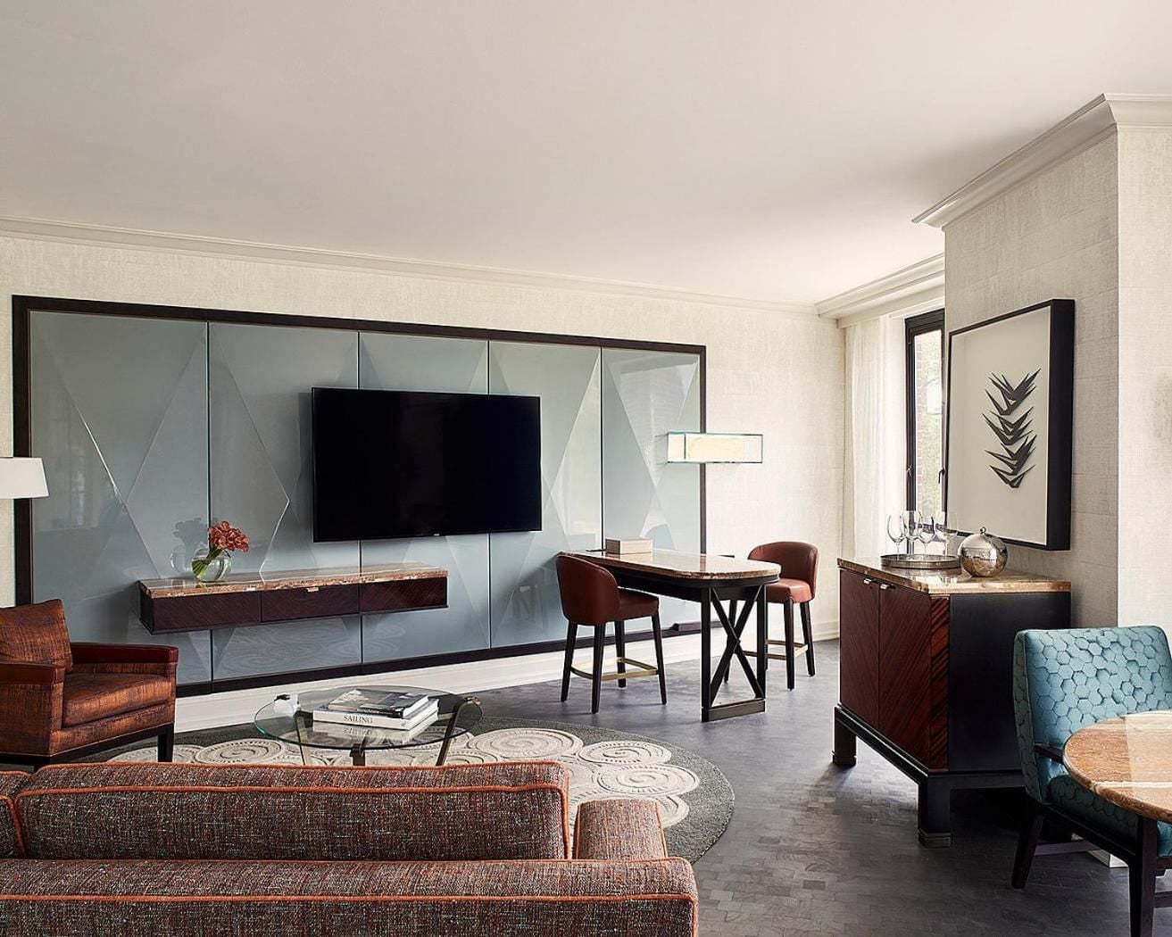 Geometric glass panels and rich mahogany furnishings create sophisticated harmony in this executive suite, where burgundy velvet chairs invite lingering over morning coffee.