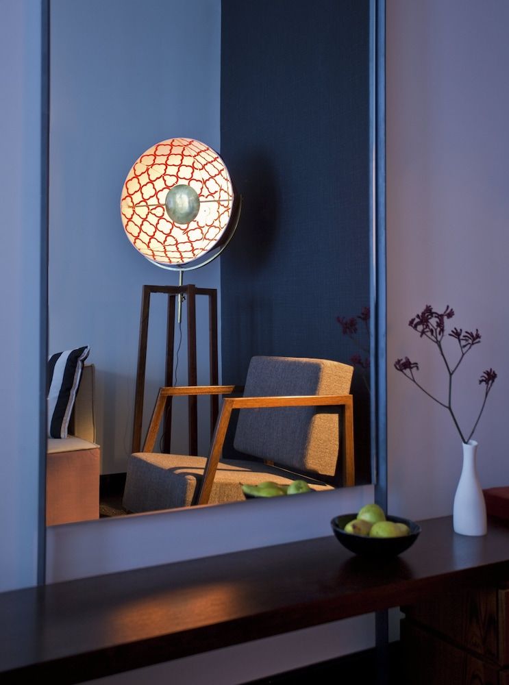 Mid-century modern furnishings catch warm lamplight in guest quarters, where geometric patterns and clean lines create an intimate reading nook perfect for evening wind-down.