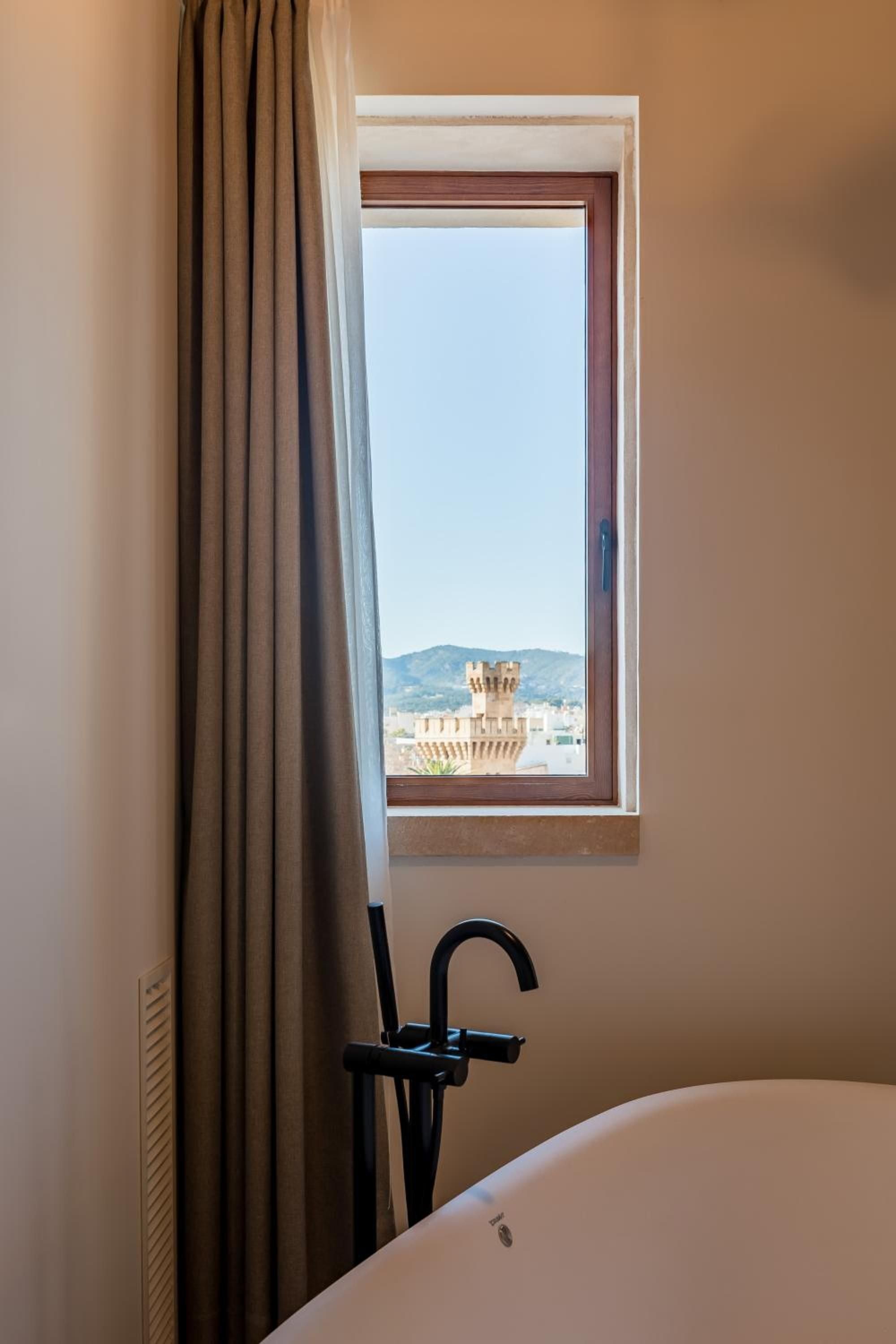 Soaking in this freestanding tub while gazing at Palma's historic fortress through tall windows creates an unexpectedly intimate connection between indulgence and heritage.