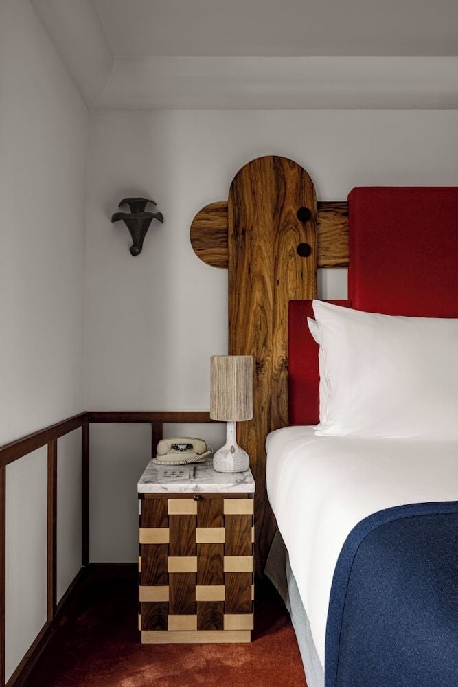 Alpine-inspired design meets modern luxury in this intimate bedroom corner, where rich wood headboards and checkerboard nightstands create a sophisticated mountain retreat.