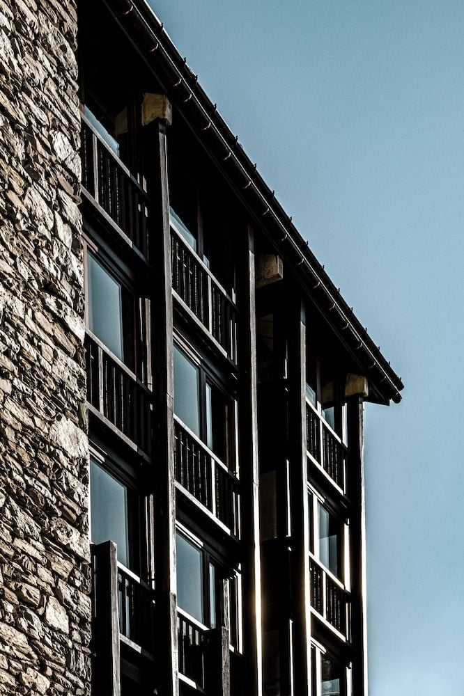 Stone meets timber in perfect Alpine harmony, where traditional chalet architecture showcases weathered textures and French balconies that frame mountain mornings with authentic Val d'Isère charm.