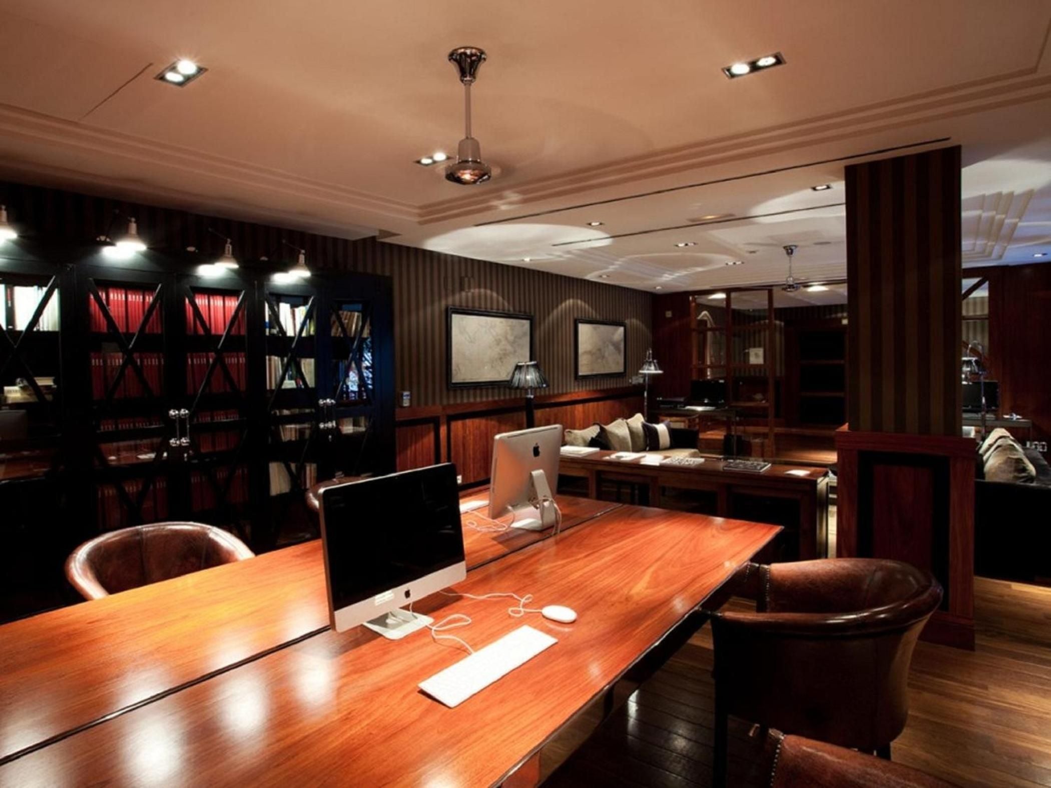 Rich mahogany panels and leather chairs create an intimate workspace where modern technology meets Old World elegance in this sophisticated business lounge.