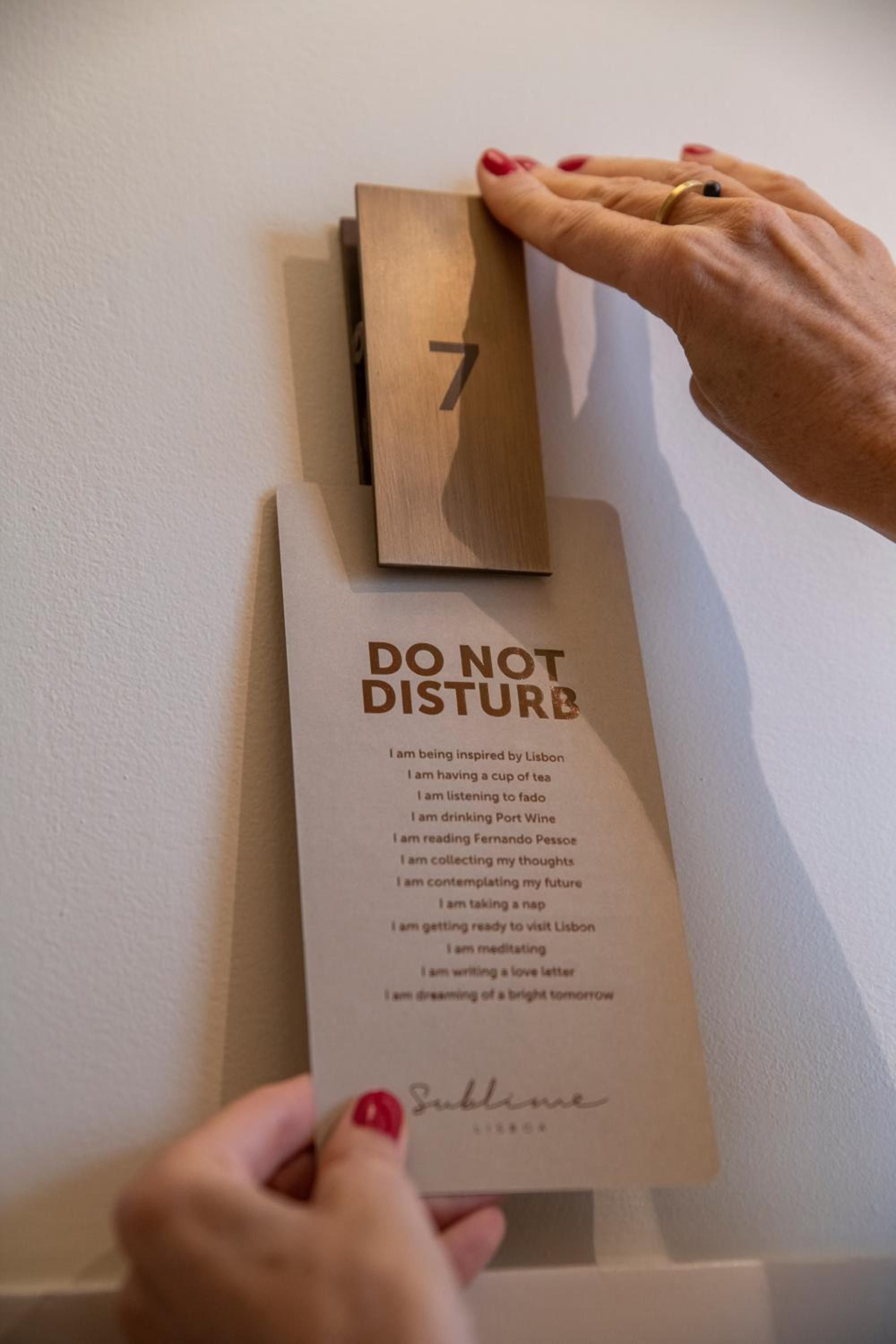 Thoughtfully crafted do-not-disturb signs reveal Sublime Lisboa's attention to guest experience, offering poetic alternatives to standard hotel requests with warm wooden touches.