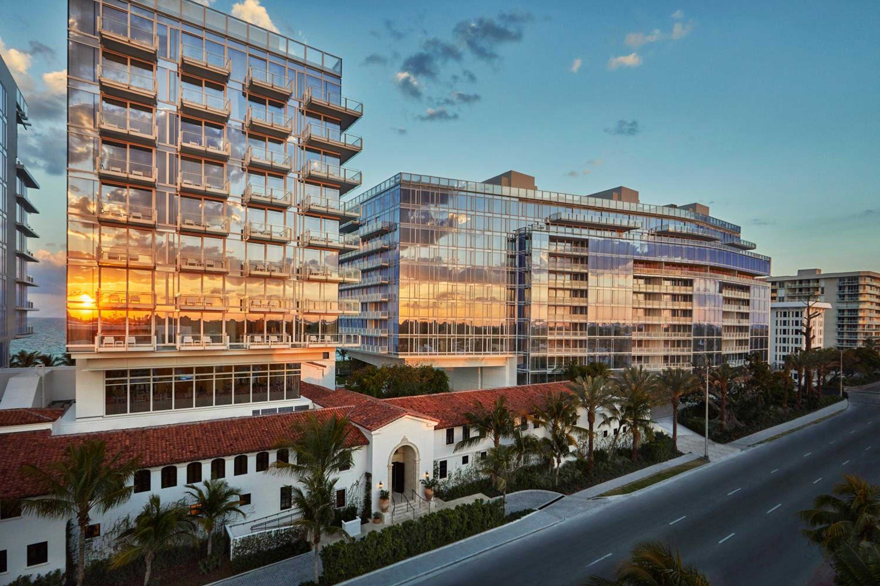 Glass towers catch golden hour light behind the preserved 1930s Surf Club, where Mediterranean revival architecture meets sleek modernity along Surfside's oceanfront.