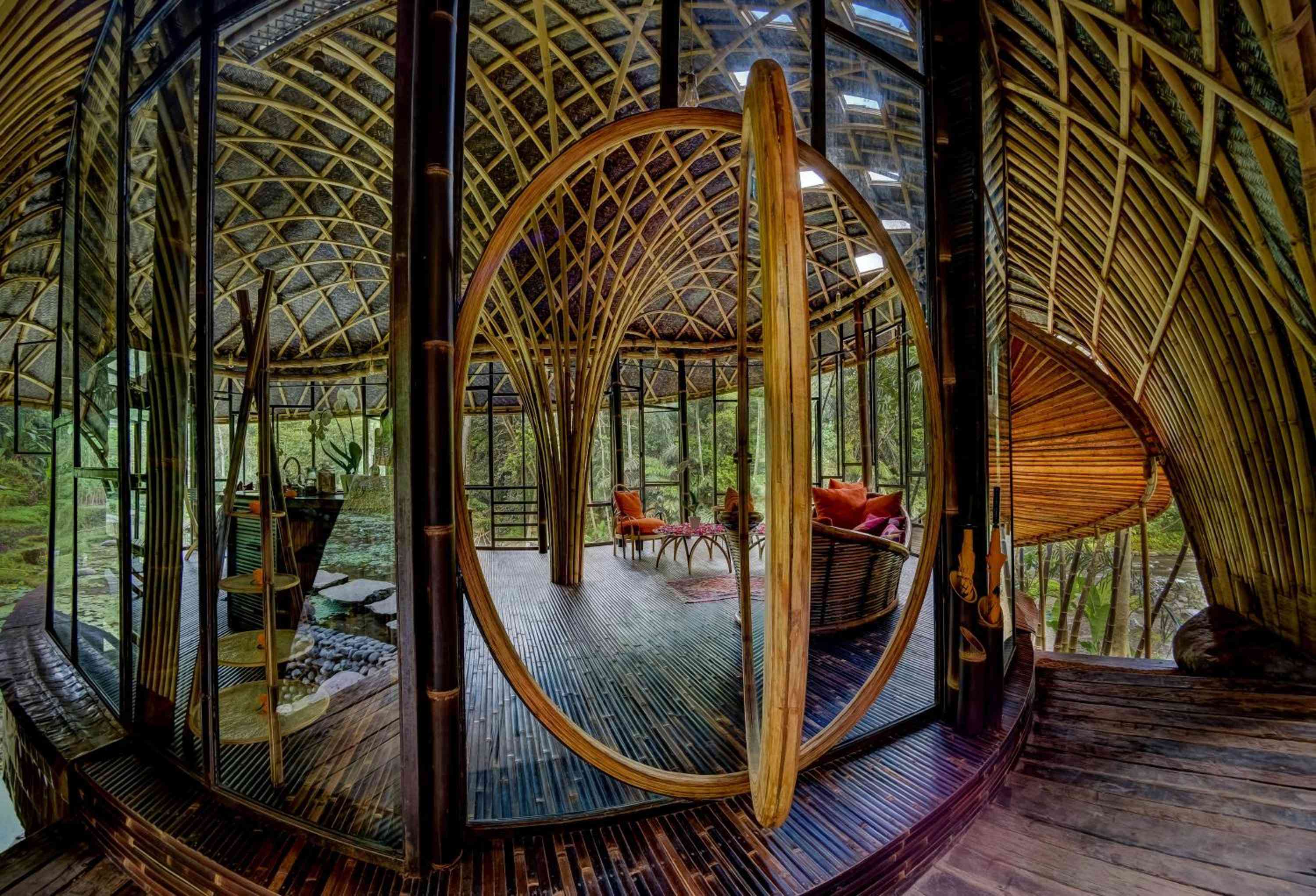 Curved bamboo doorways frame intimate seating nooks beneath soaring latticed ceilings, where handwoven textures and forest views blur the boundary between shelter and nature.