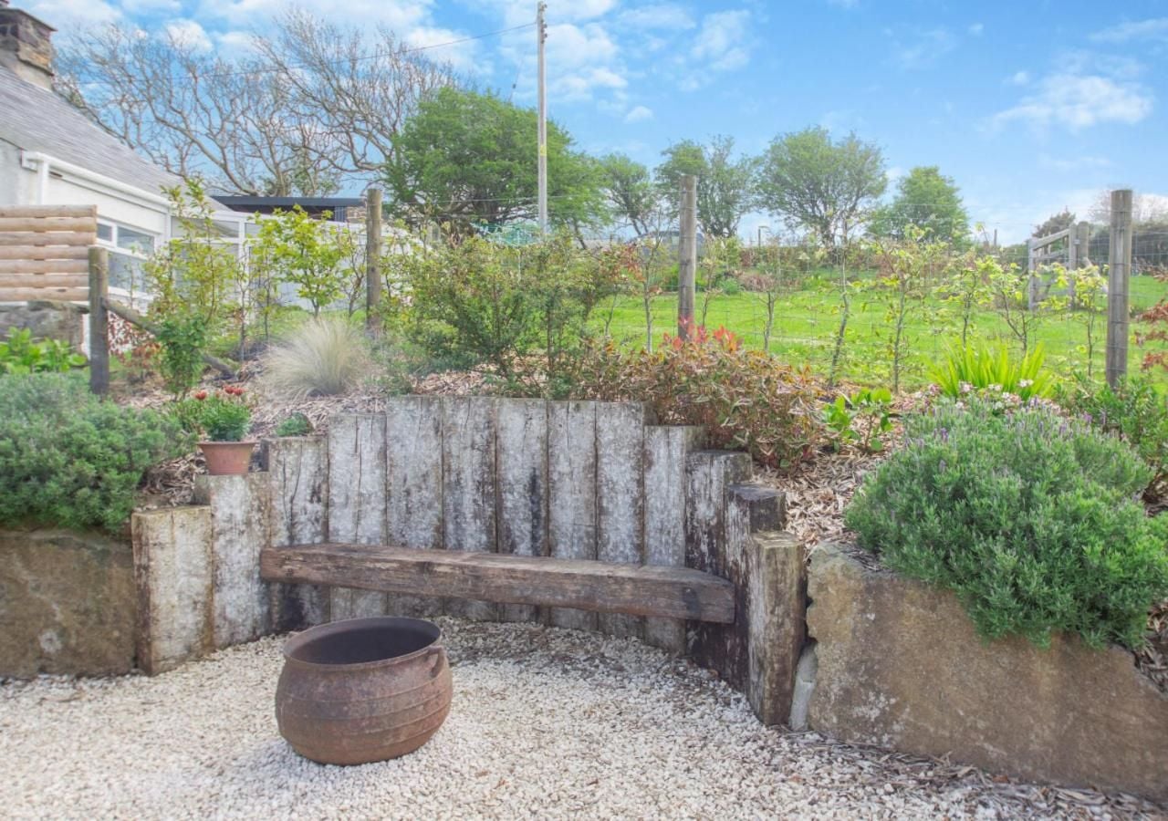 Weathered timber benches nestle against rustic stone walls in the kitchen garden, where ceramic vessels and aromatic herbs create an intimate sanctuary for quiet contemplation.