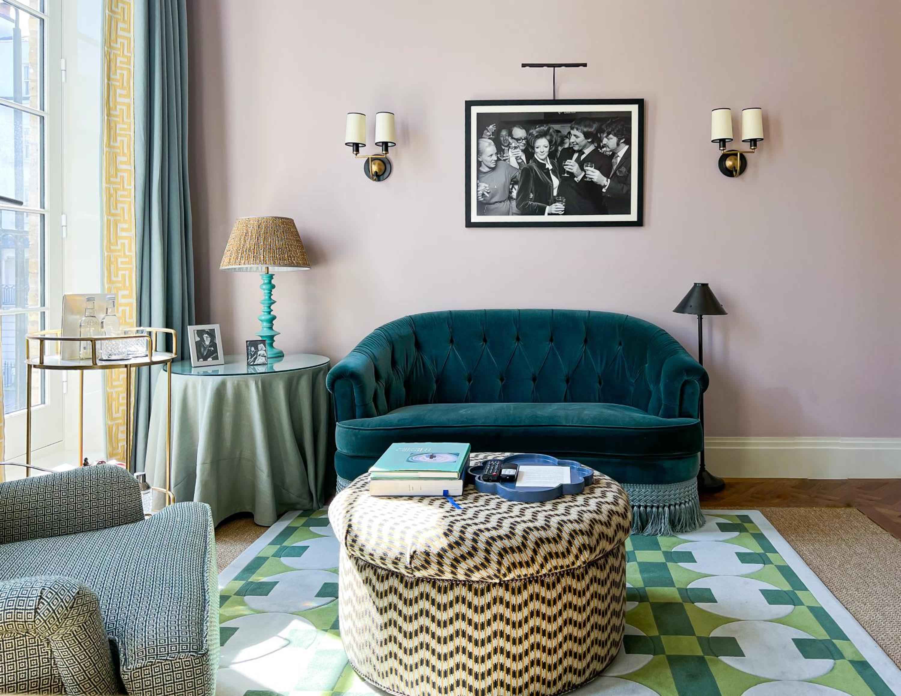 Blush-pink walls and jewel-toned velvet create an intimate salon where vintage Hollywood glamour meets British sophistication, complete with tufted emerald seating and geometric patterns.
