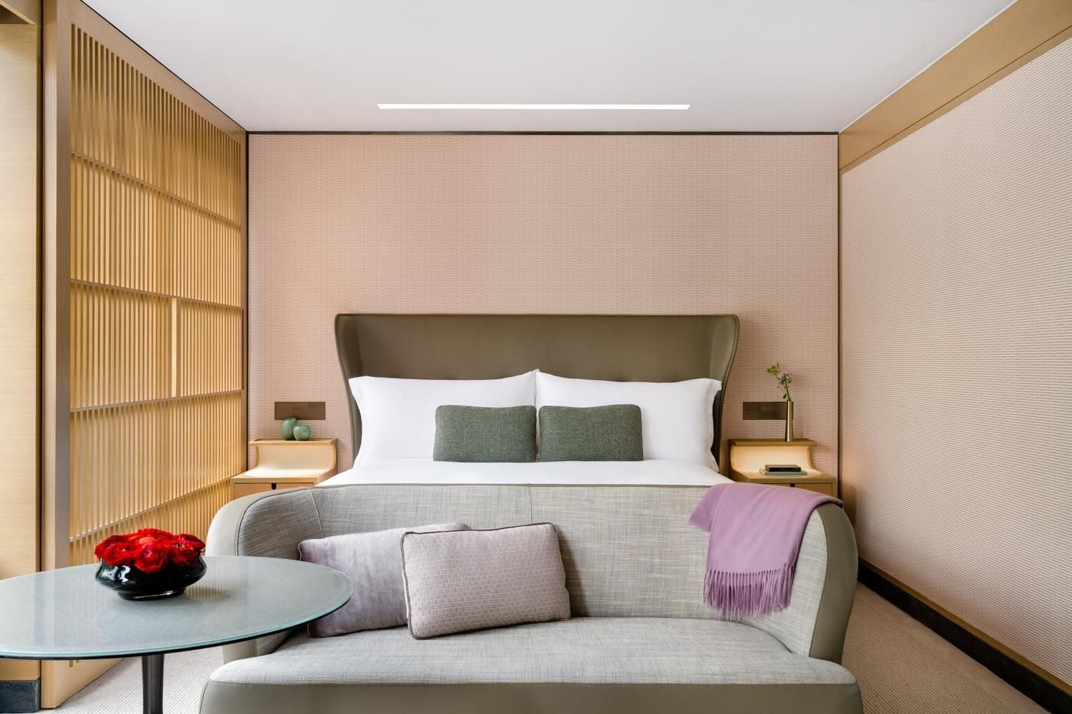 Warm wood lattice panels and blush-toned textures create an intimate sanctuary, where contemporary comfort meets subtle Asian-inspired design details.