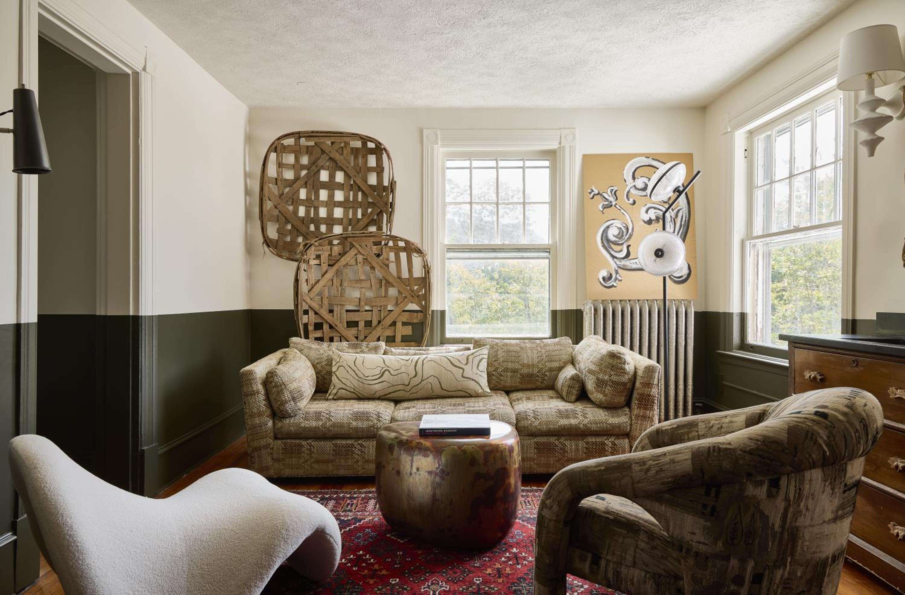 Woven tobacco baskets and rich velvet seating create an intimate corner where contemporary art meets Appalachian craftsmanship beneath soft afternoon light.