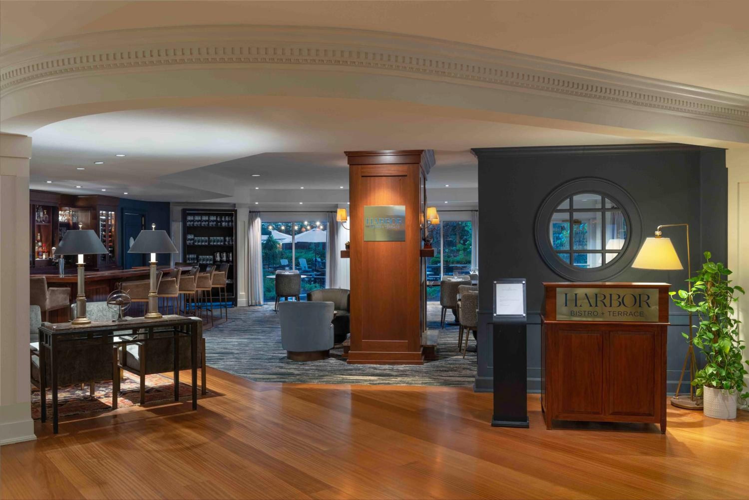Warm wood floors and nautical accents create an inviting harbor-inspired atmosphere where guests gather beneath soaring arched ceilings for elevated dining experiences.