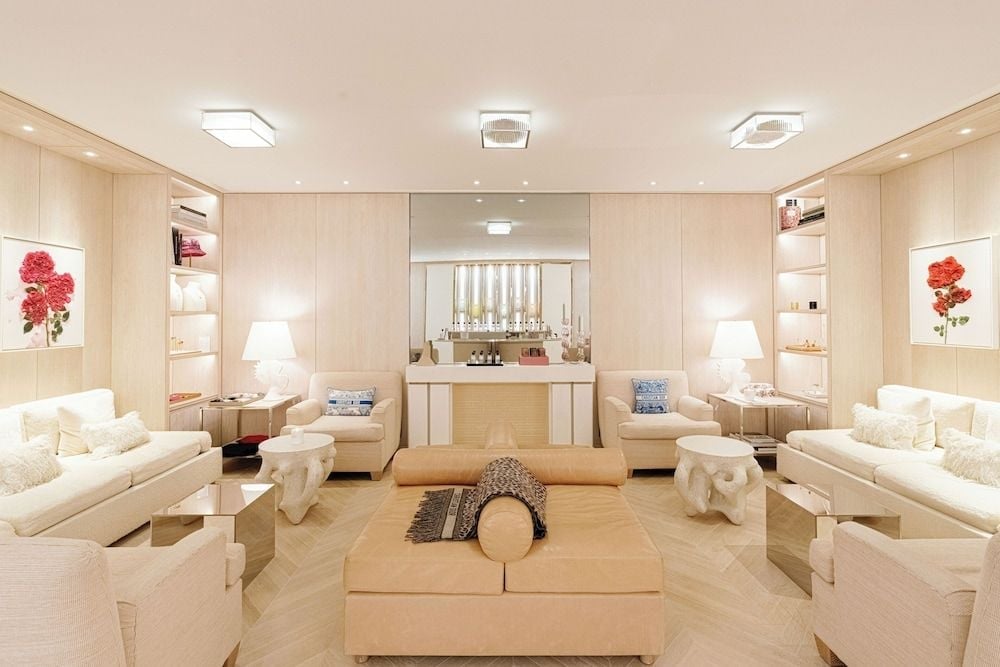 Warm blonde wood and cream leather create a cocoon-like sanctuary where guests sink into plush seating beneath softly glowing pendant lights.