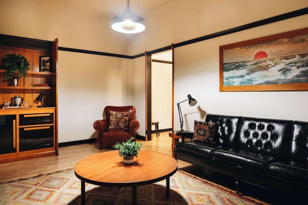 Warm wood tones and tufted black leather create an inviting retreat, where mid-century modern furnishings blend seamlessly with the hotel's storied athletic club heritage.