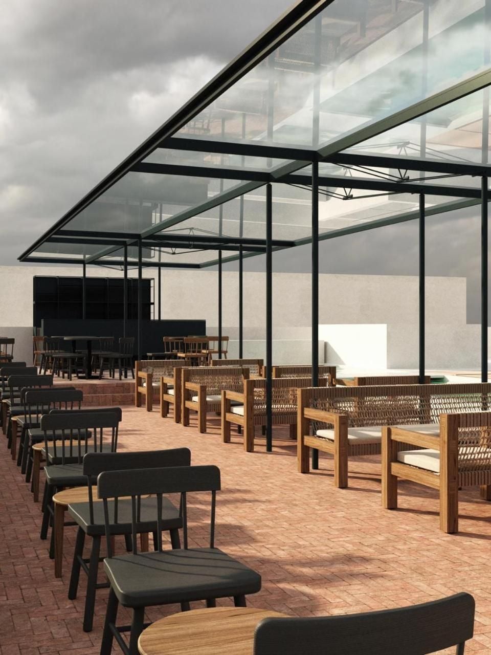 Woven rattan seating and sleek glass canopies create an airy terrace dining experience where contemporary Mexican design meets open-sky sophistication under dramatic clouded skies.