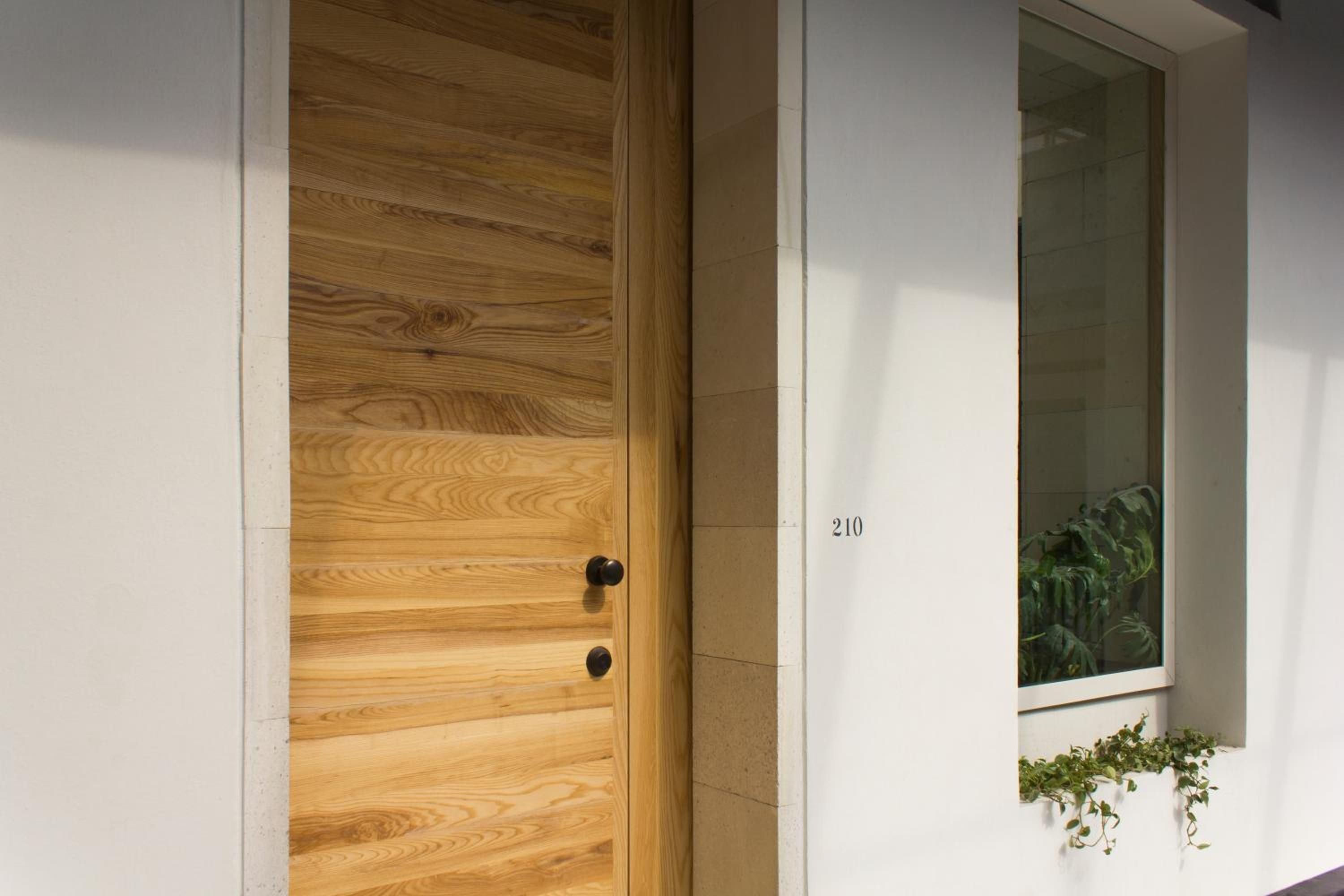 Natural oak grain meets minimalist concrete in thoughtfully designed corridors, where warm wood textures and clean lines create an understated elegance throughout the property.